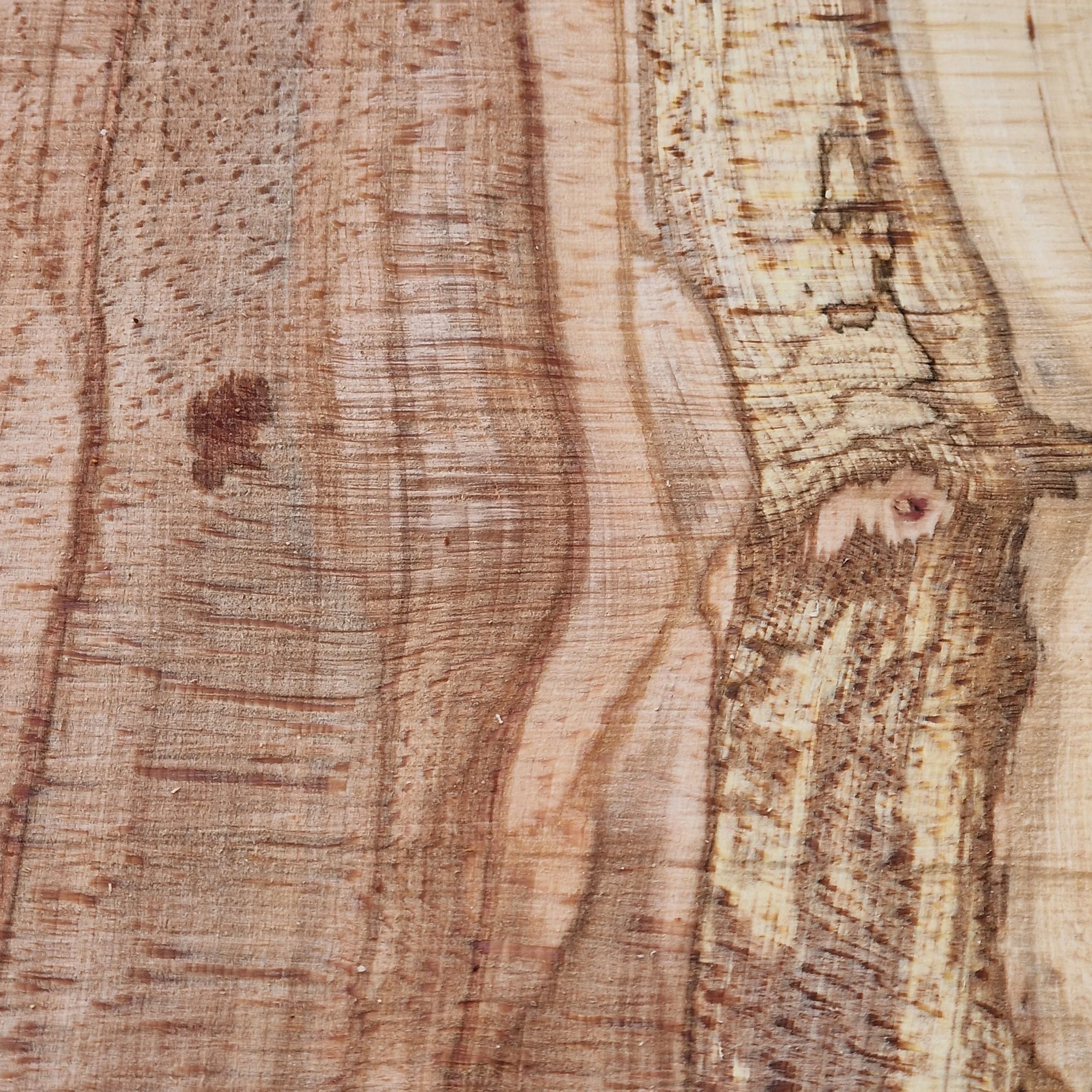 Close-up of a wooden surface showing natural wood grain and knots.