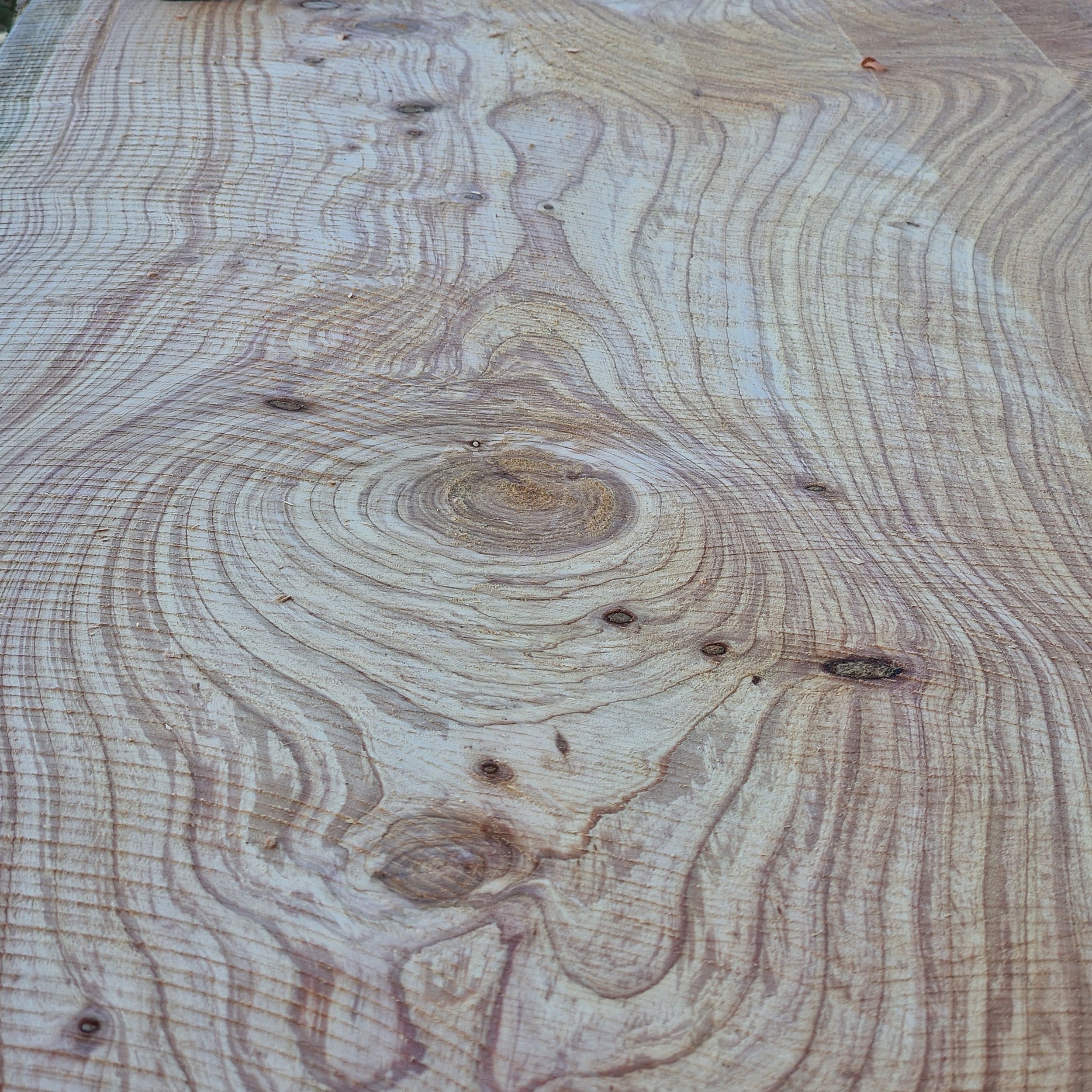 Close-up of a wood surface showing natural grain patterns and knots.