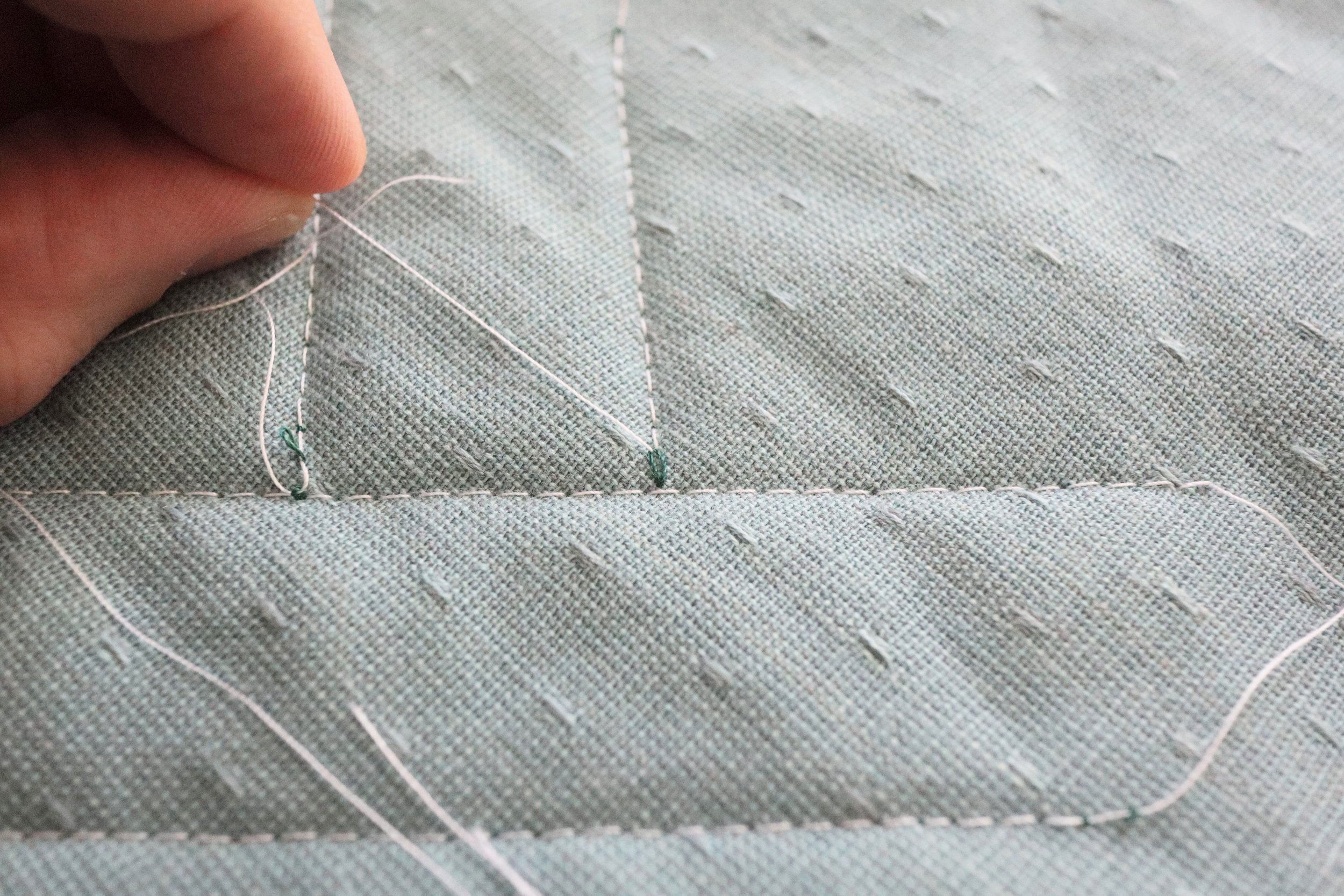 Pull the top thread until you see a small loop.