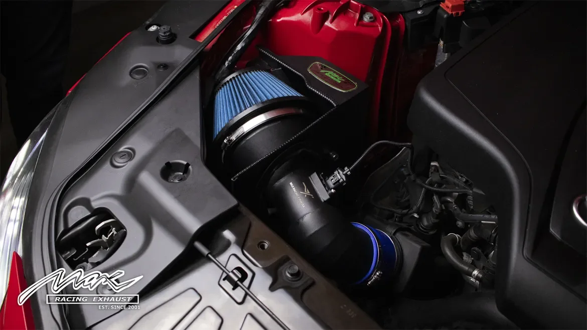 A black Toyota sports car with the hood open, exposing the engine and orange suspension components inside a garage.