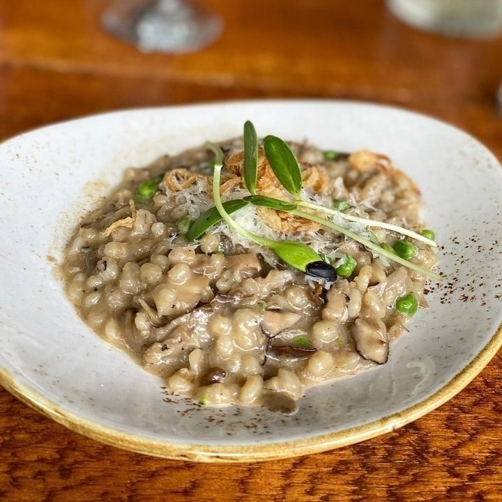 Savor each delicious and comforting bite of our Barley Risotto with local mushrooms, peas, truffle, and crispy shallots🌿

📸: @eatingwithsol