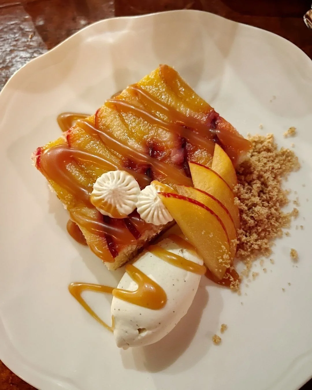 End your evening on a sweet note with our Plum Upside Down Cake, layered with vanilla cream, graham cracker, and caramel. ✨