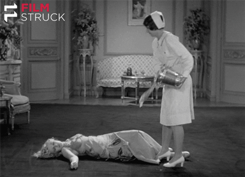 A vintage black-and-white scene of a nurse throwing a bucket of water on a reclining patient, humorously representing how RDAs need a wake-up call to better reflect modern nutrient needs.