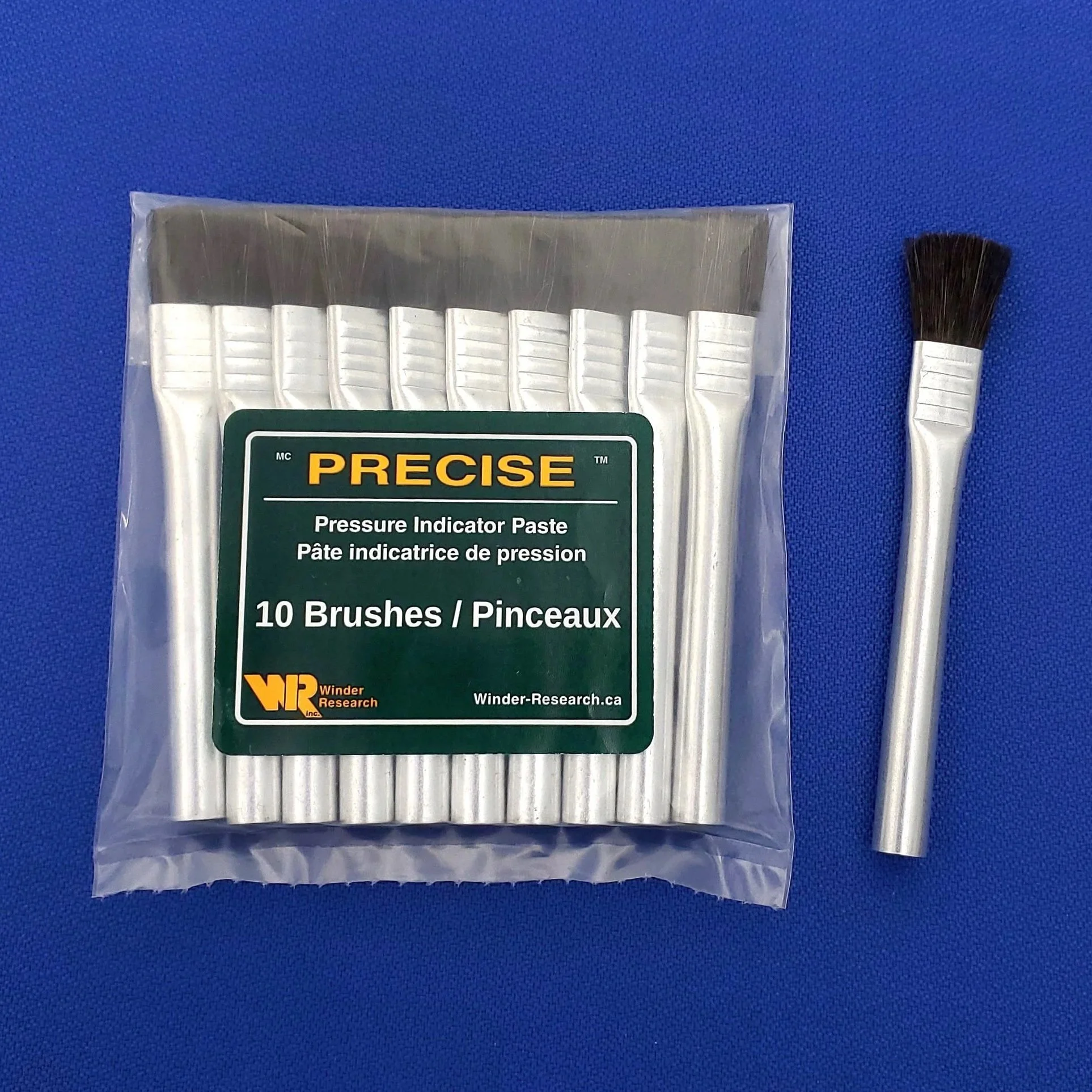 Package of 10 aluminum pressure indicator paste brushes with black synthetic bristles, placed on a blue surface.