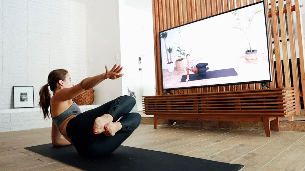Woman following a Dance Toned workout on a television at home