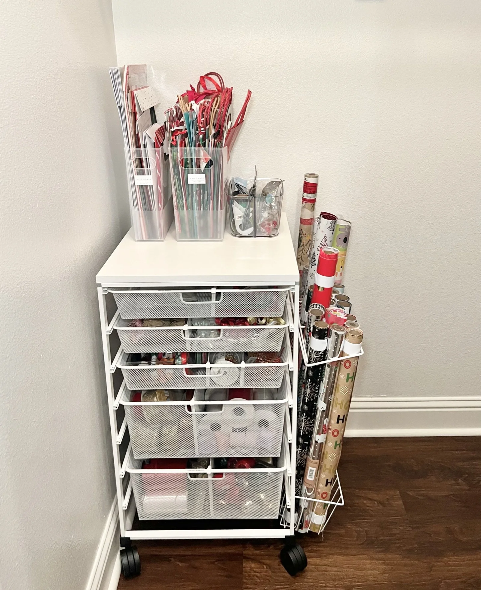 Rolling cart organized as a gift wrapping station with wrapping paper, tape, tags, and gift bags