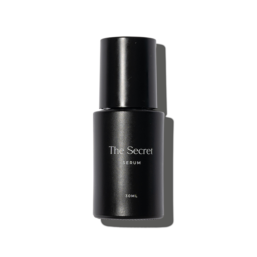 A black bottle labeled 'The Secret Serum 30ML' on a background divided into black, gray, and blue sections.