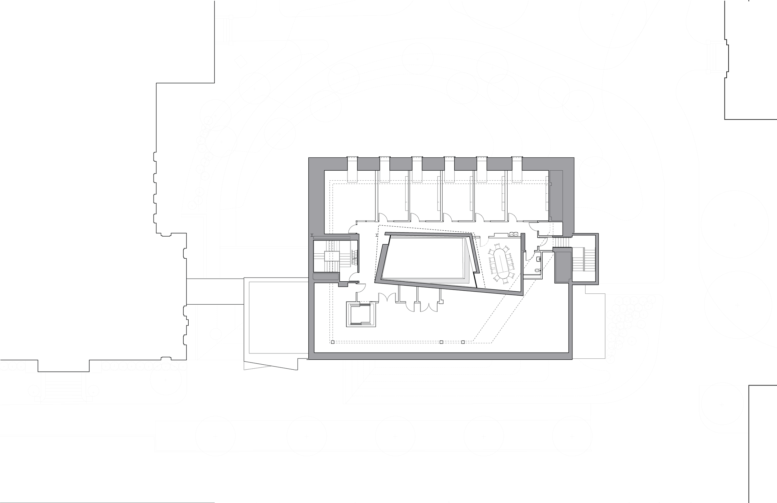 Architectural floor plan of a building with multiple rooms, central open space, staircase, and outdoor landscaping.