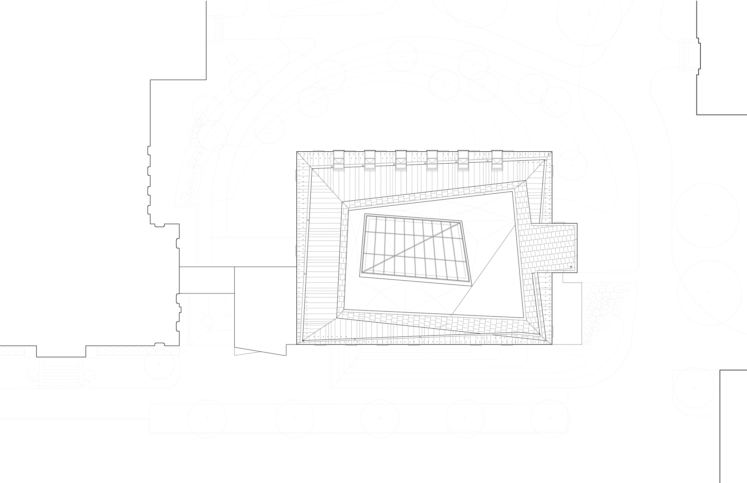 Top view of a building roof with a square tower and surrounding roof structures, with faint landscape features around it.