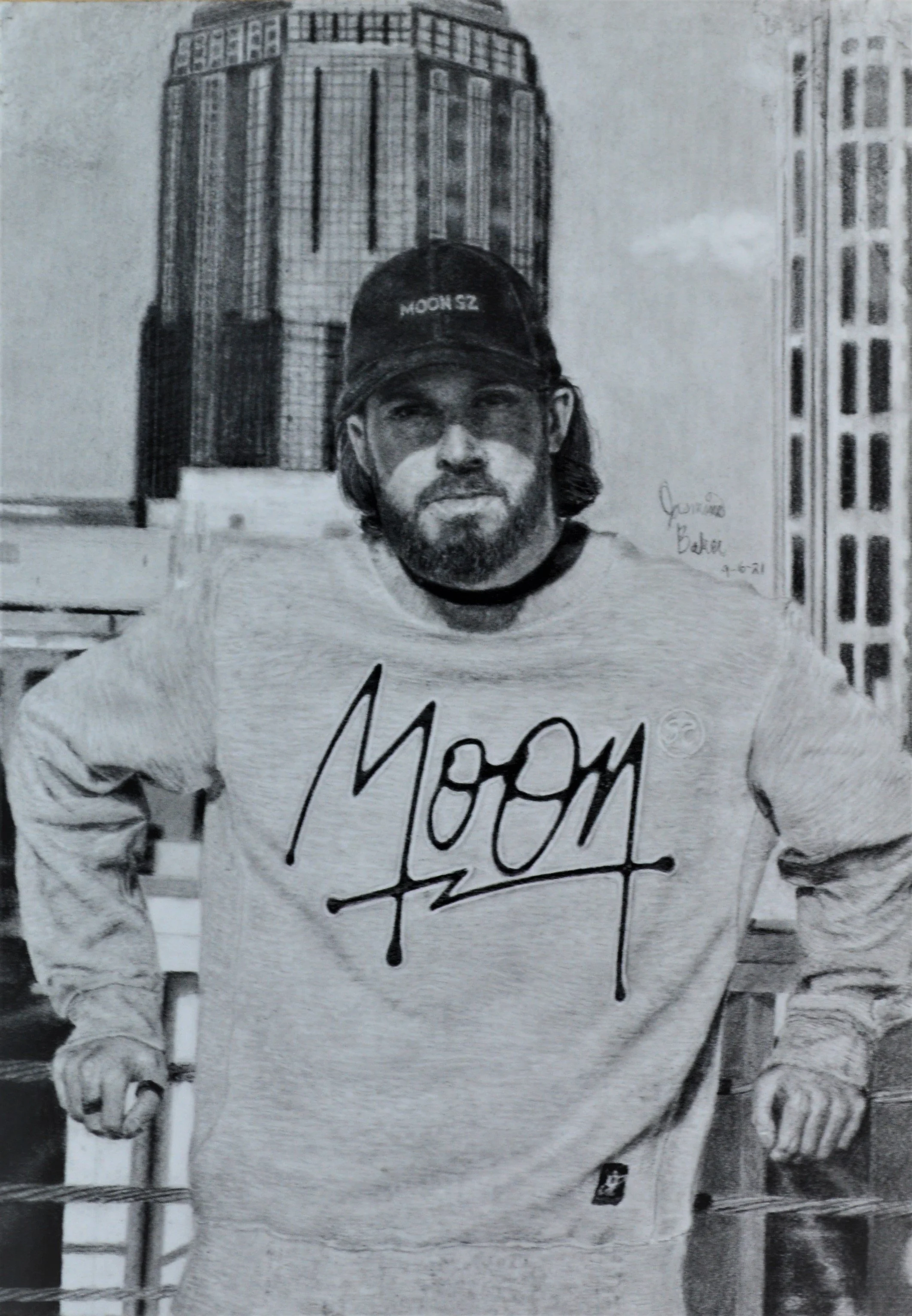Charcoal drawing of a man named Abstract, wearing a "MOON 52" hat and sweatshirt, standing in front of a city building 