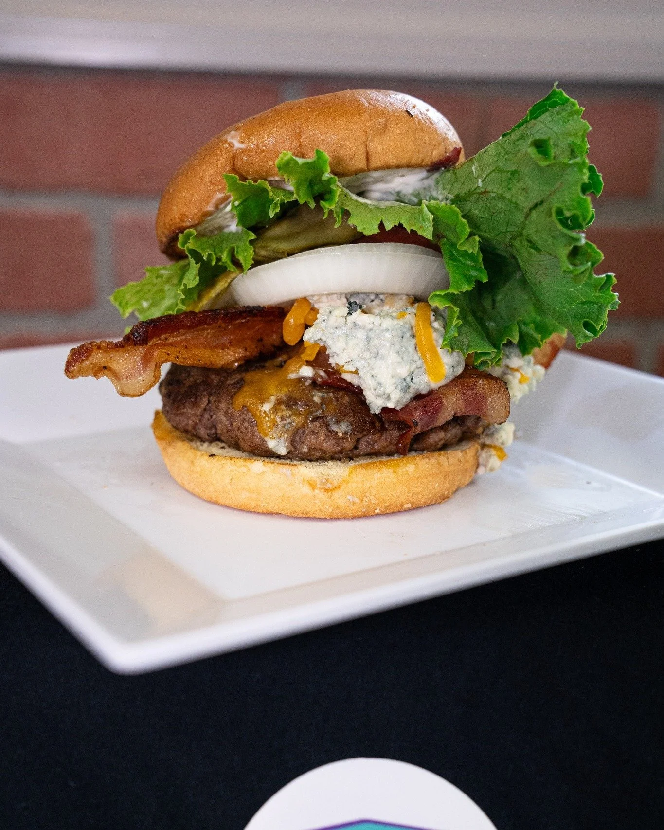 Big, bold, and loaded with flavor.
Our Blue Mountain Burger comes stacked with a juicy hamburger patty, crispy bacon, melted cheddar, and tangy blue cheese. A classic combo with serious kick.