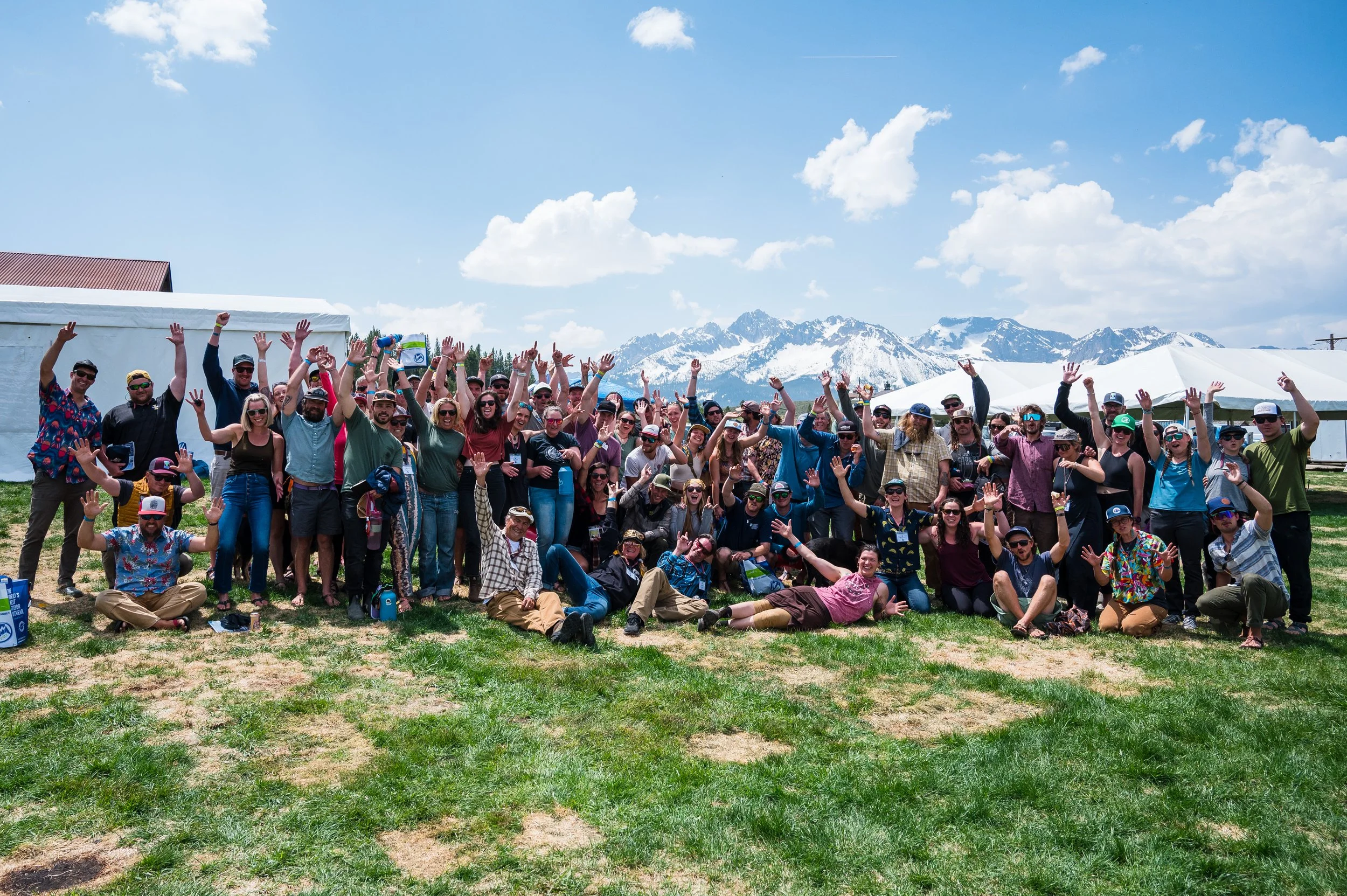 People white water rafting in a river surrounded by rocky cliffs and green trees in a canyon.