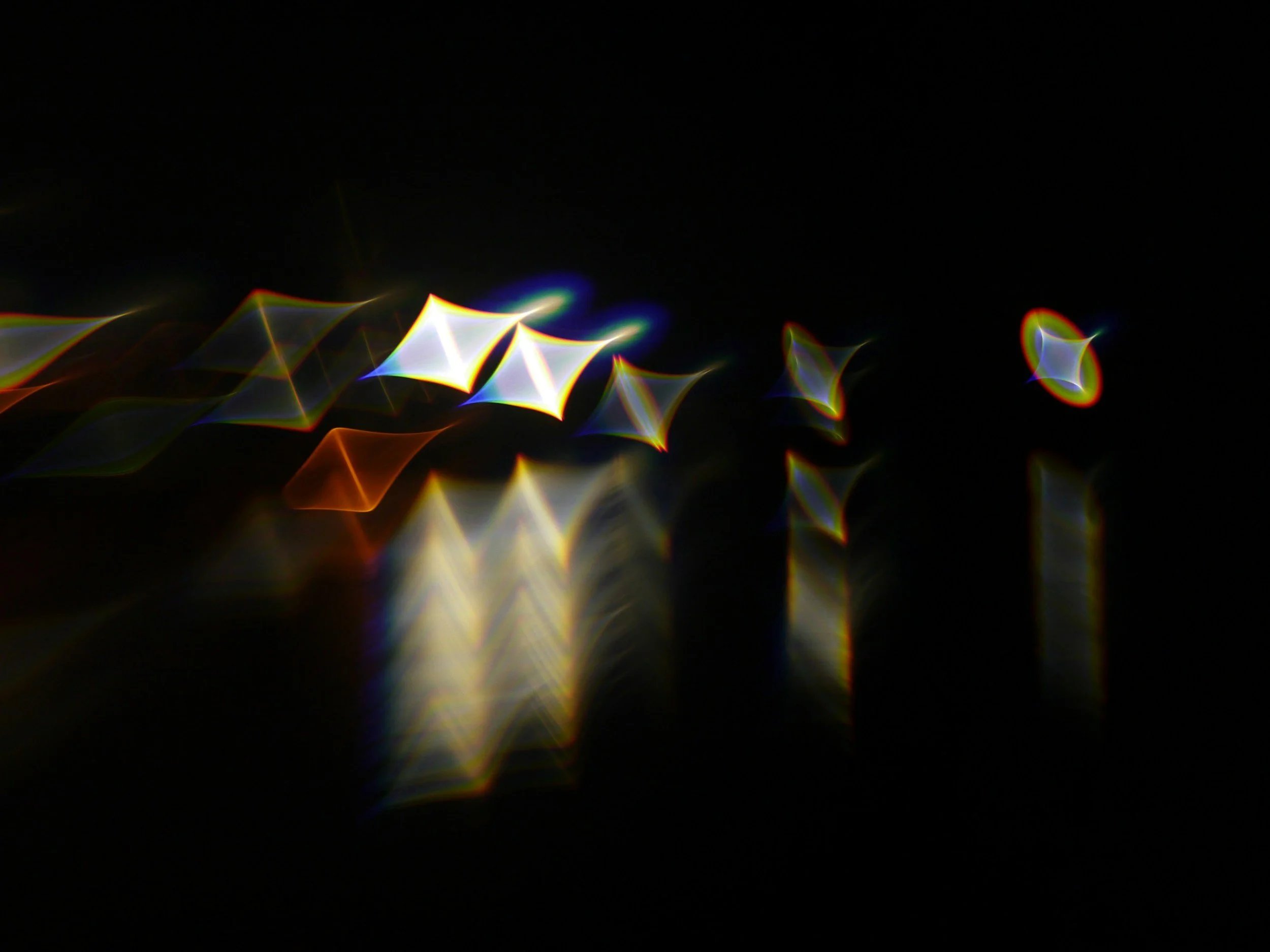 Colorful abstract light shapes against a black background.