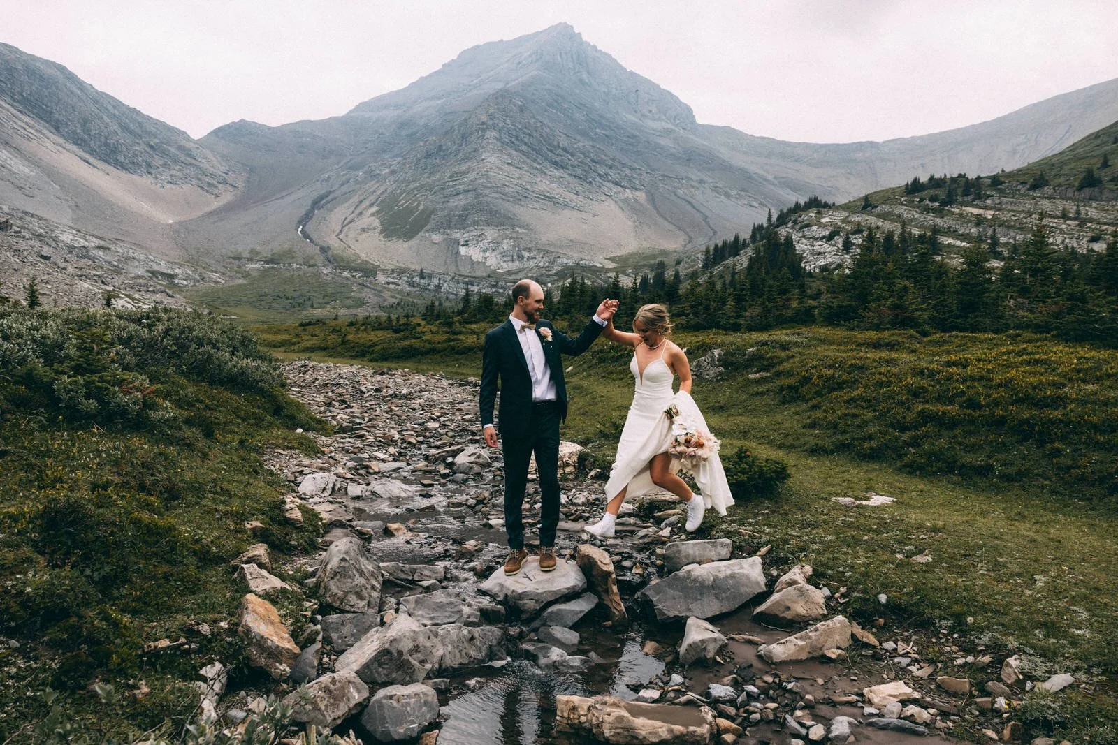 Couple jumping over rocks