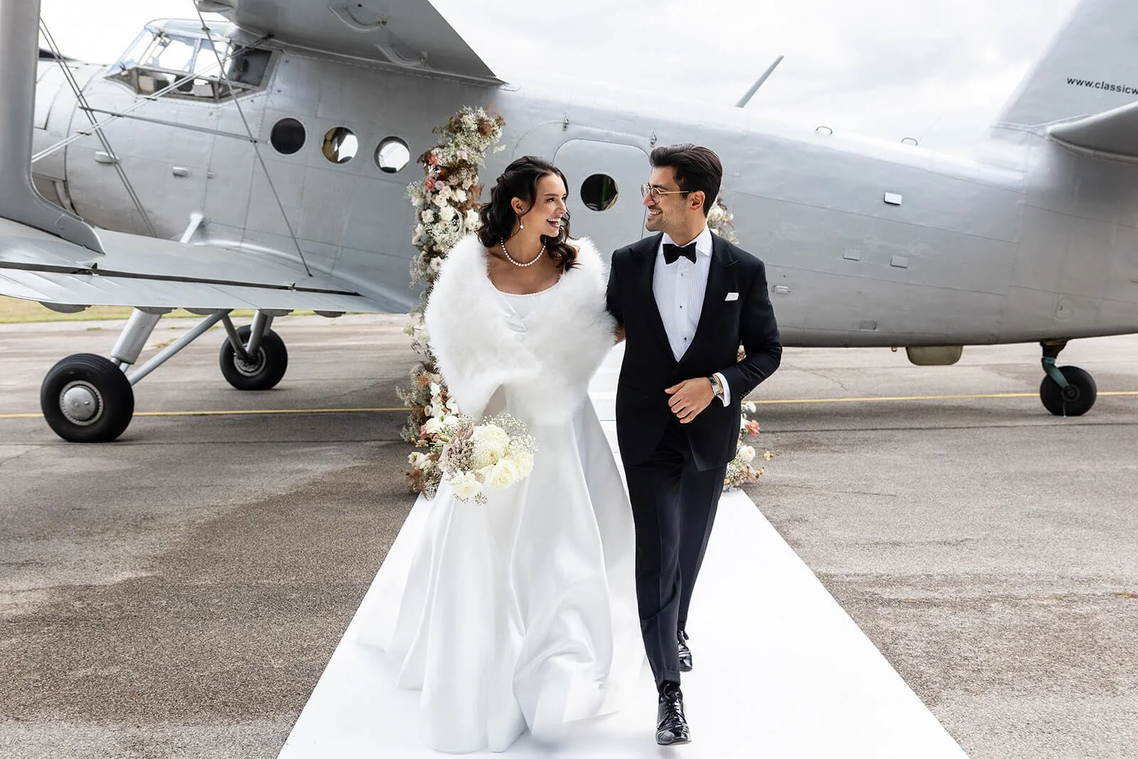 Married couple with airplane in the background.
