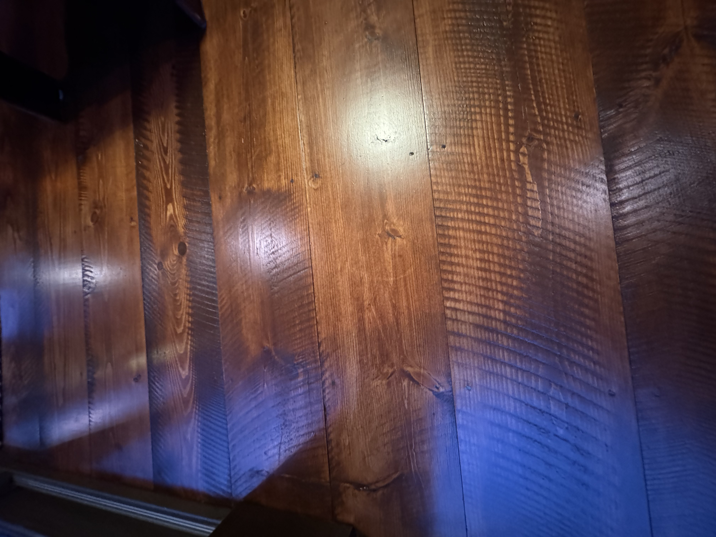 Close-up of a polished wooden floor with visible wood grain and knots.