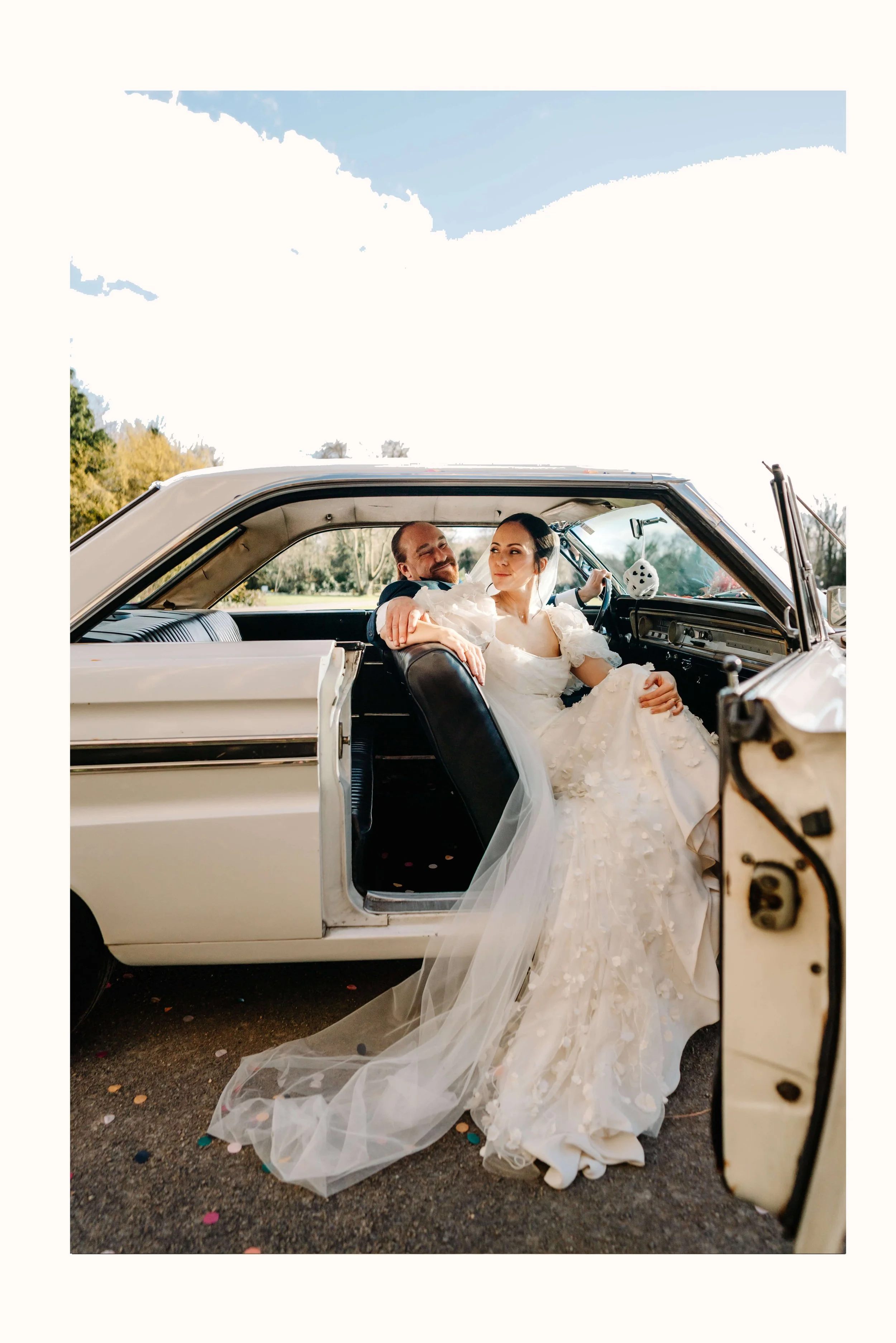 Vintage car at Elmore Court during a wedding, couple posing sitting inside the car and looking out.