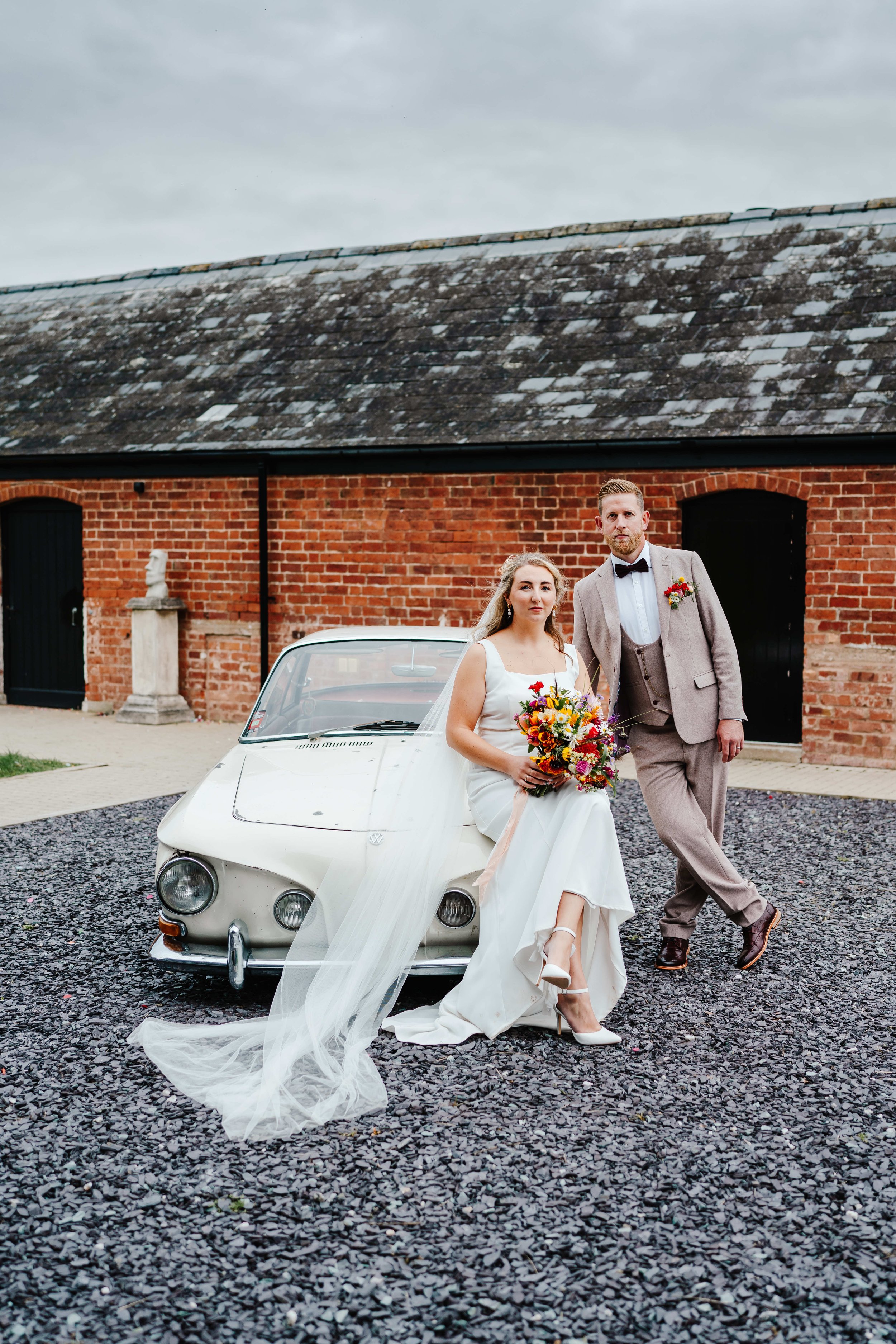 Wedding couple at Crumplebury posing on vintage car