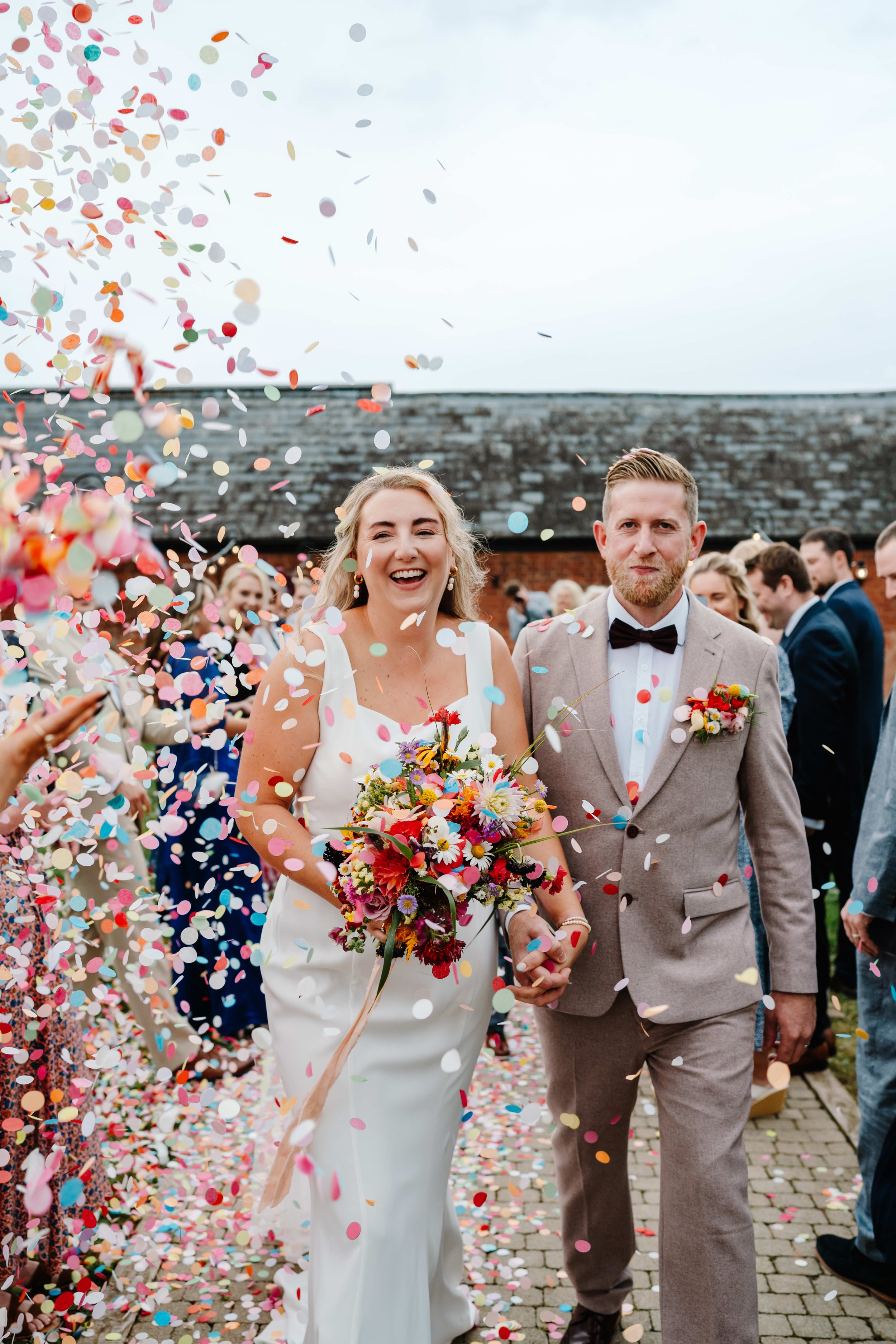 Couple on their wedding day at Crumplebury during confetti moment