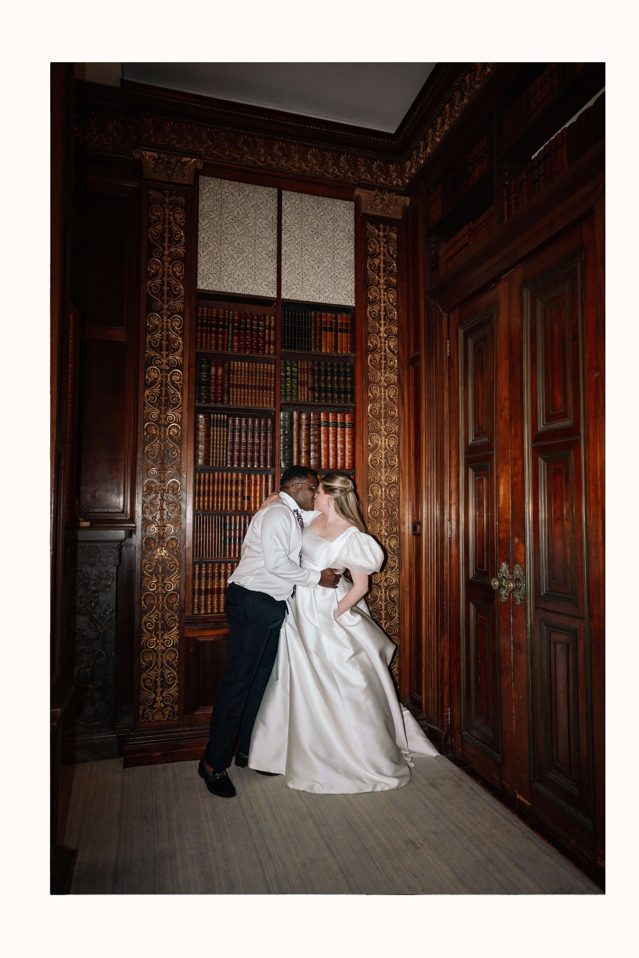 Couple kiss in grand room at Clevedon Hall on their wedding day, flash photography