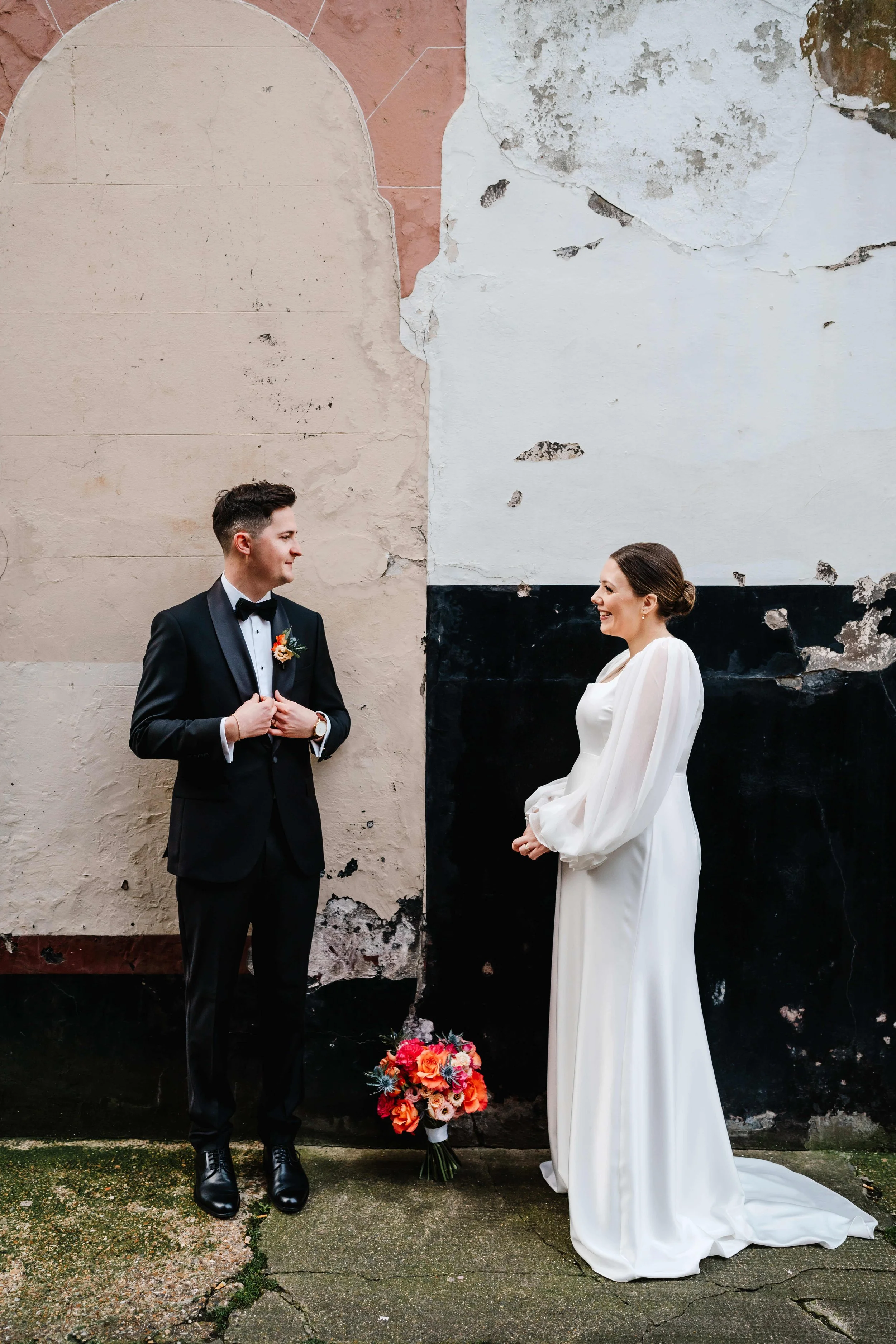 A bride and groom standing face to face near to Old Marylebone Town Hall