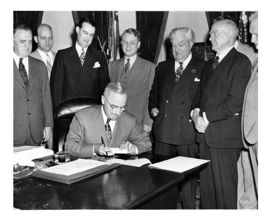 Harry Truman signs the APA, June 11, 1946. Behind him, from left to right, are: Congressman John Gwynne (R-Iowa); Counsel for the House Judiciary Committee, Charles E. Long, Jr.; Representative of the Attorney General, Ashley Sellers; Representative