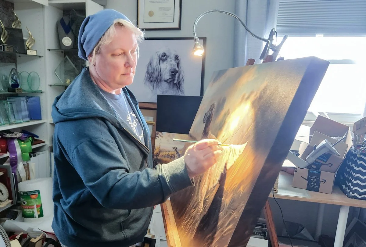 photograph of artist Danica Barreau embellishing a digital painting with acyrlic.