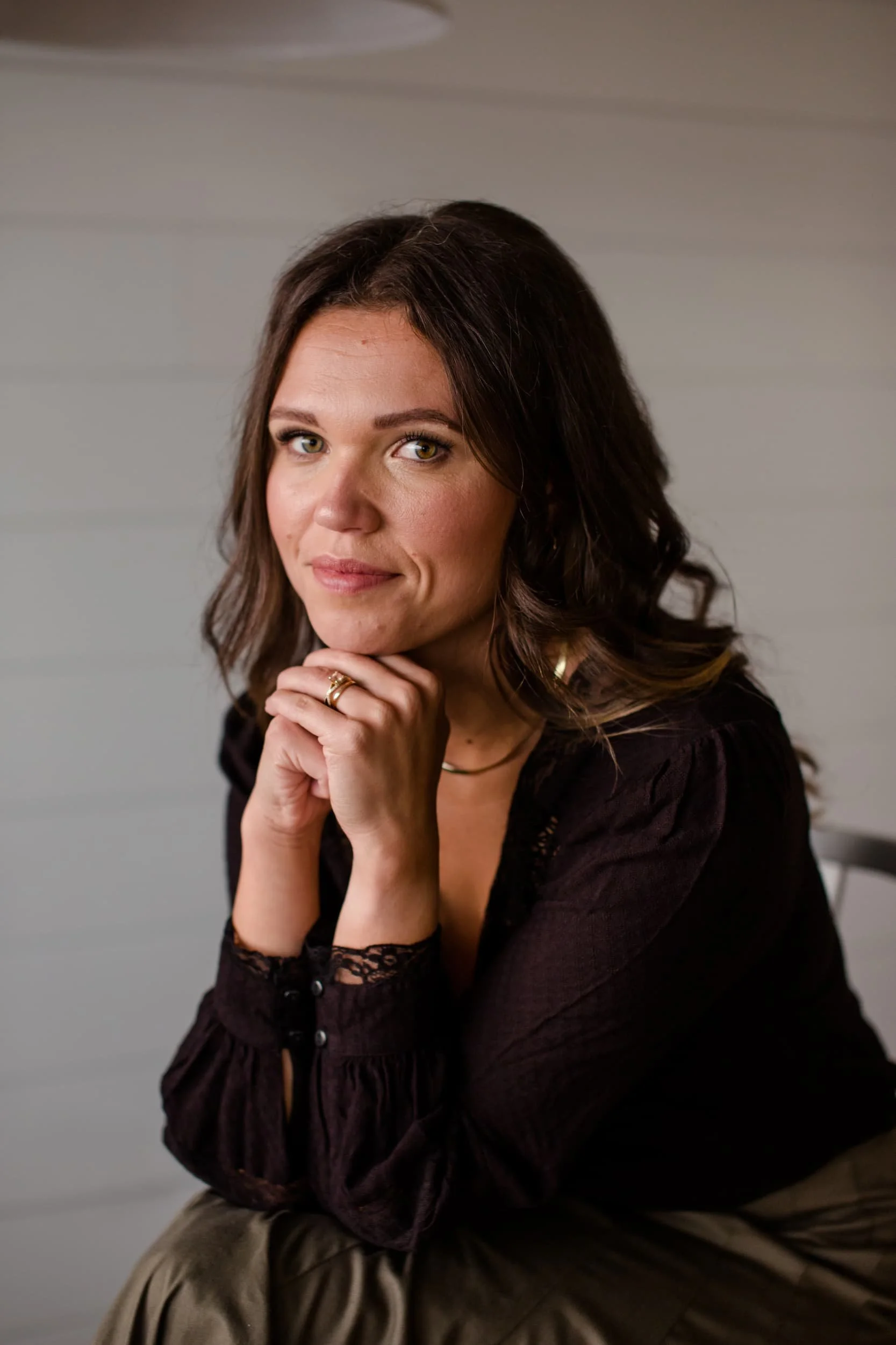 Paulina Cameron is gently smiling with her hands under her chin