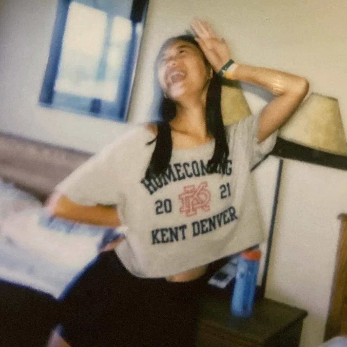 asian american teen smiling wearing a gray homecoming shirt