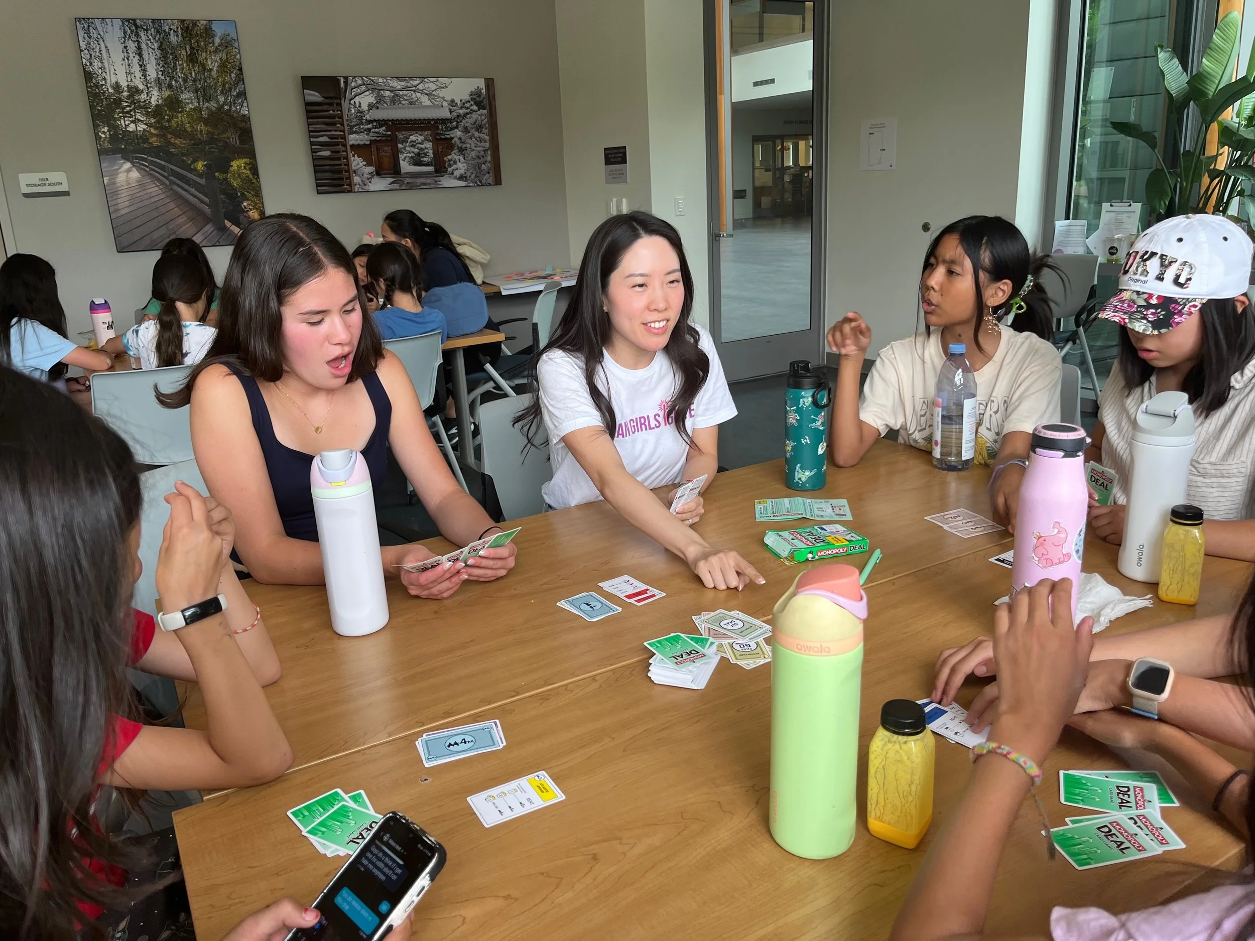 Mehgan playing Monopoly Deal with AGI students