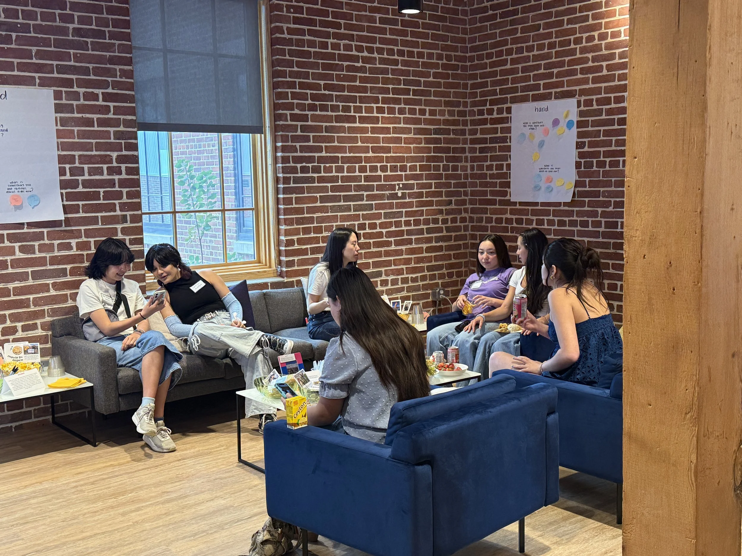  Students in the living room space talking and eating snacks 