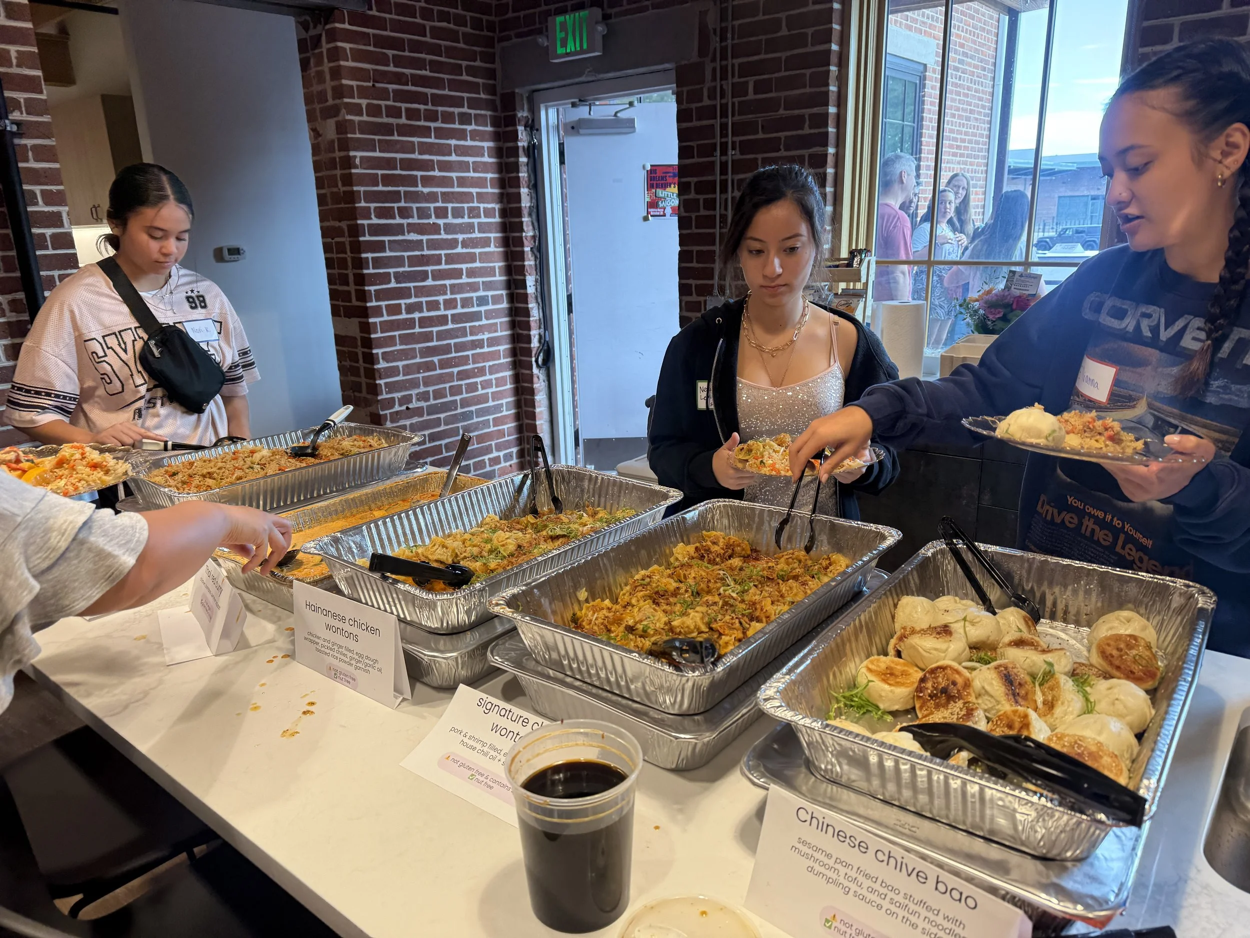  Students line up for catering from Yuan Wonton at kitchen island 