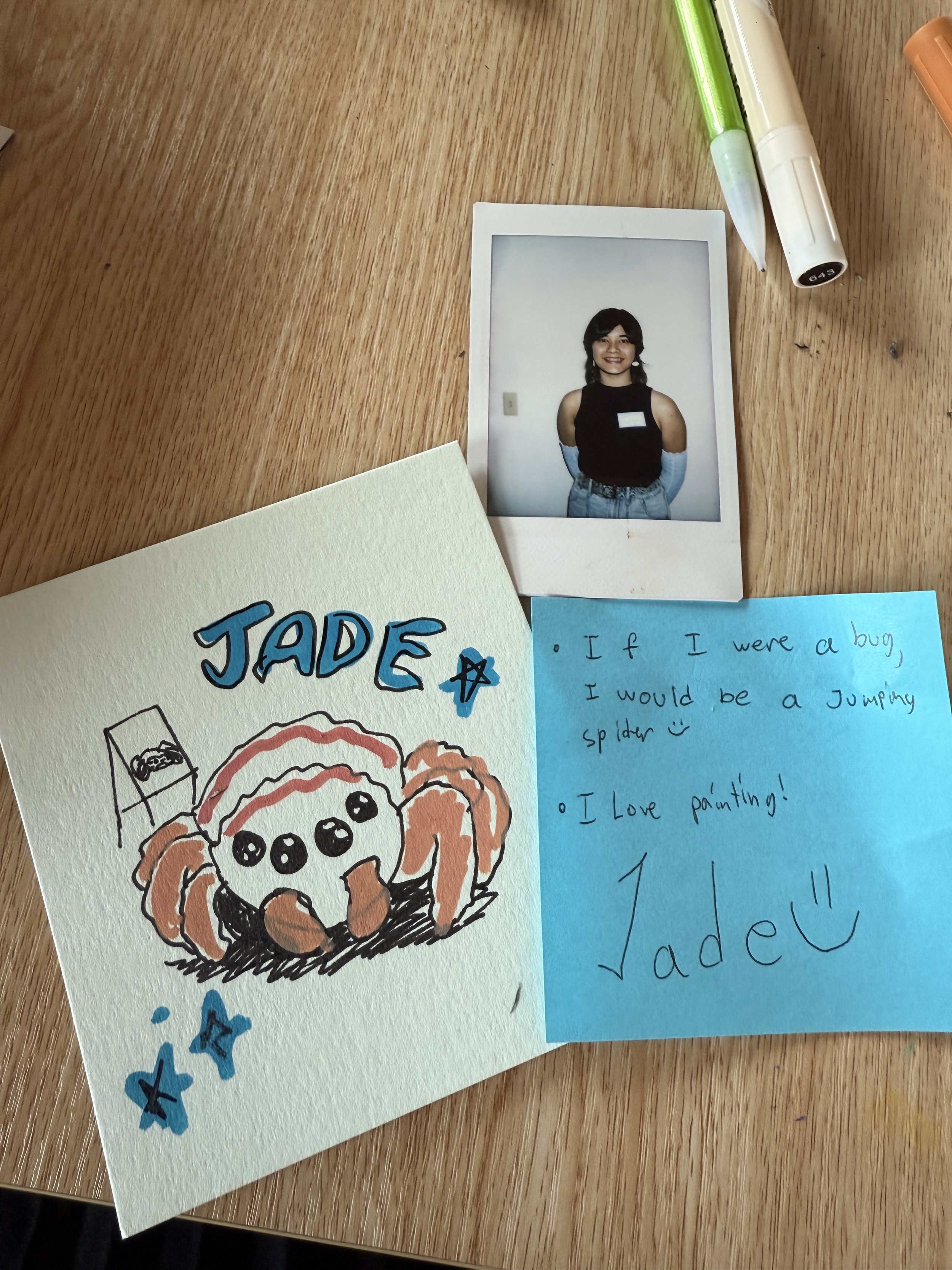  Drawing on jumping spider with polaroid at the top right and a blue sticky note on the bottom 