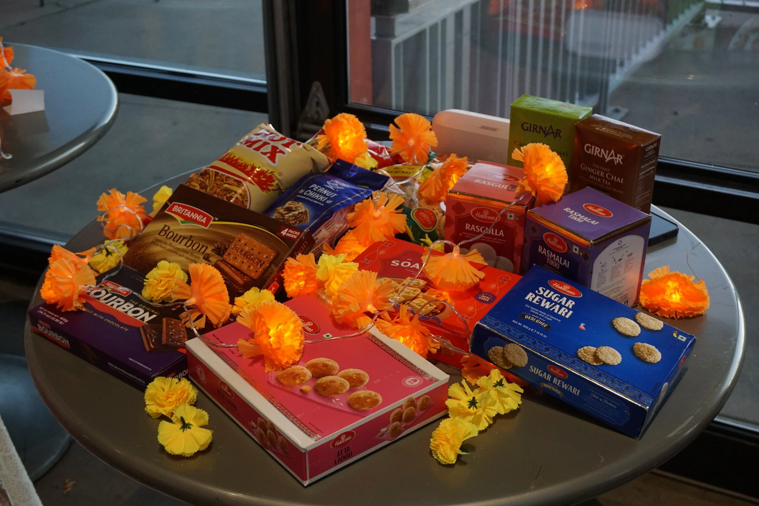  Decorated table with Indian snacks, sweets, and diwali decor. 