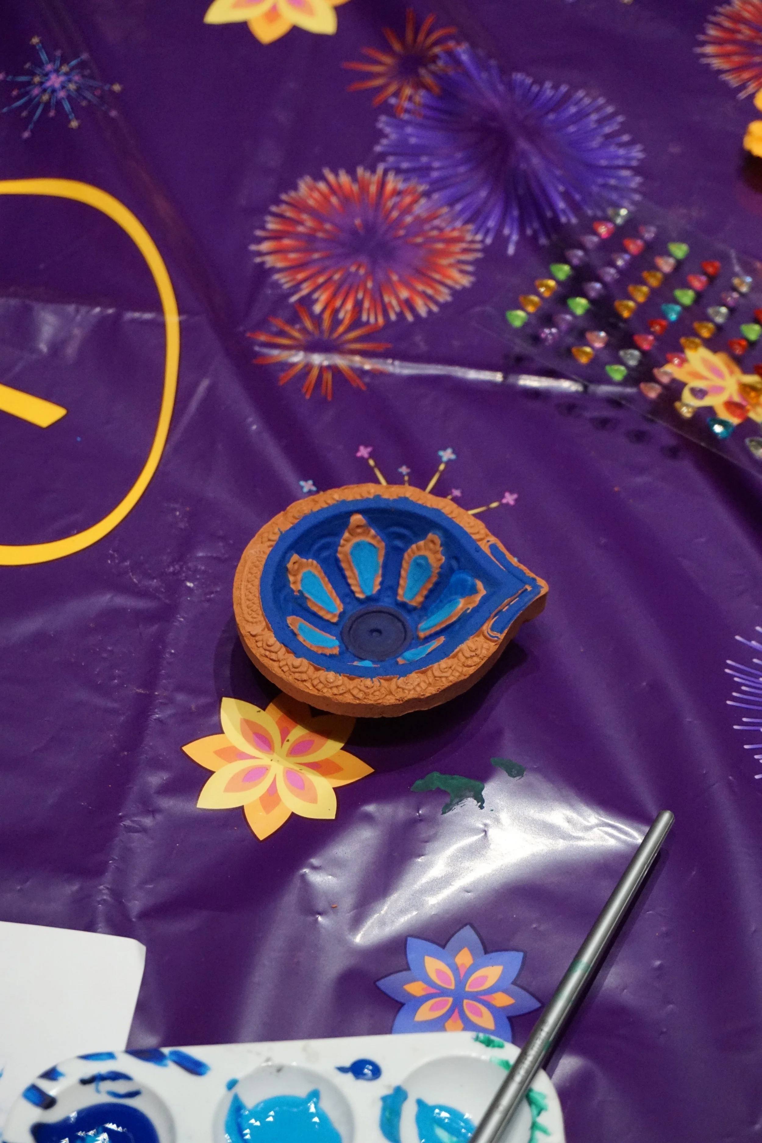 Decorated diya on purple tablecloth 