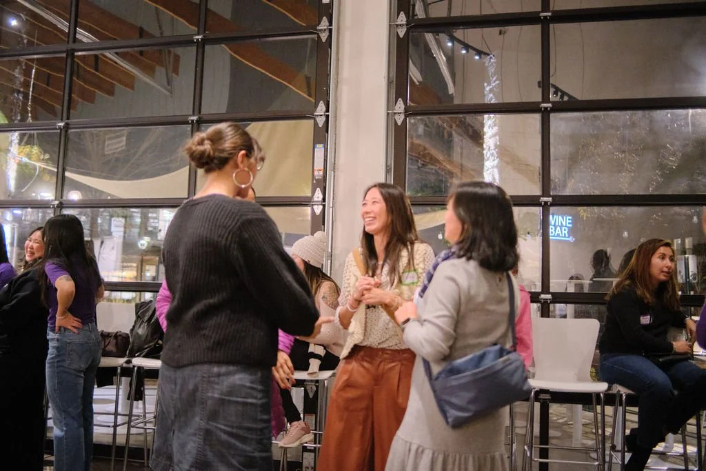  Asian Girls Ignite Board member, Elaine Yang laughs with group of community members and students at at AppreciAsian 2025 hosted at Yuan Wonton 