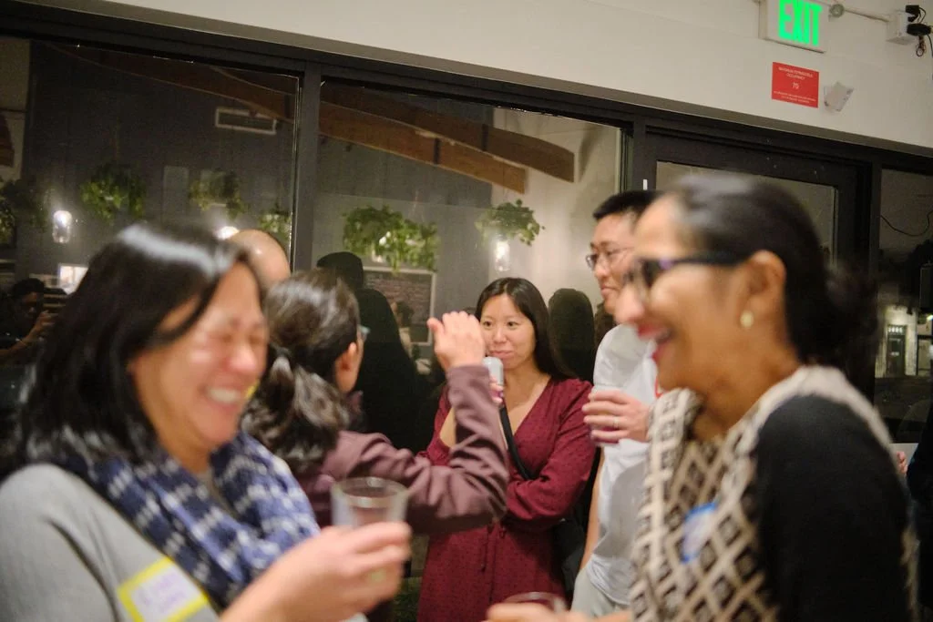  Community members in conversation and laughter at at AGI AppreciAsian 2025 hosted at Yuan Wonton 