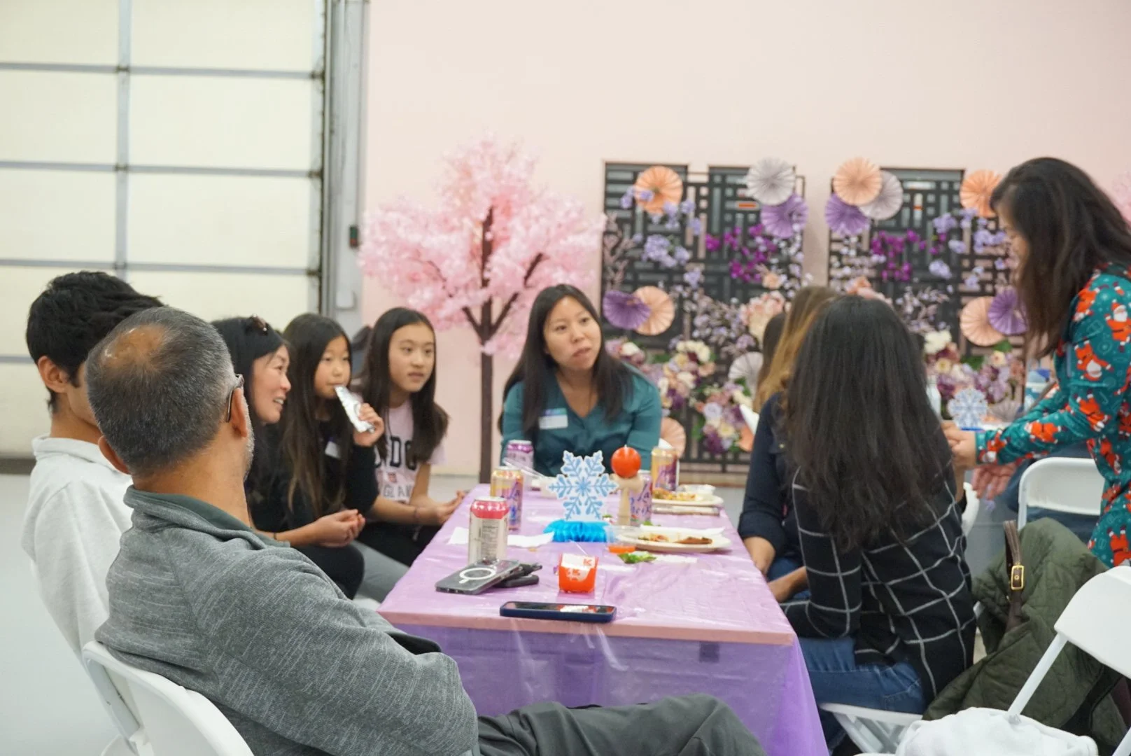  Families and students sitting at table with purple table cloths at CACEN’s Social Fabric Hub for AGI’s Holiday Social 2025 