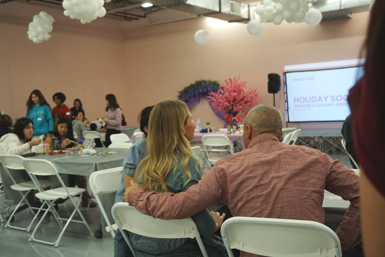  Families and students sitting at table with purple table cloths at CACEN’s Social Fabric Hub for AGI’s Holiday Social 2025 