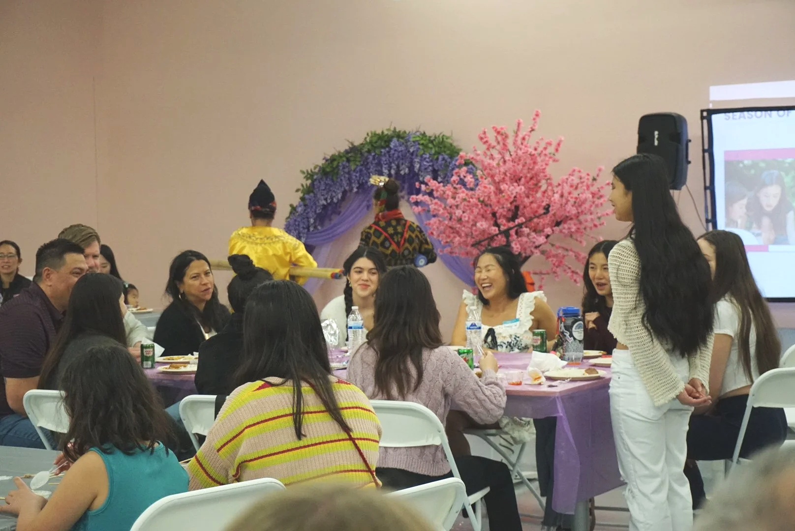  Families and students sitting at table with purple table cloths at CACEN’s Social Fabric Hub for AGI’s Holiday Social 2025 