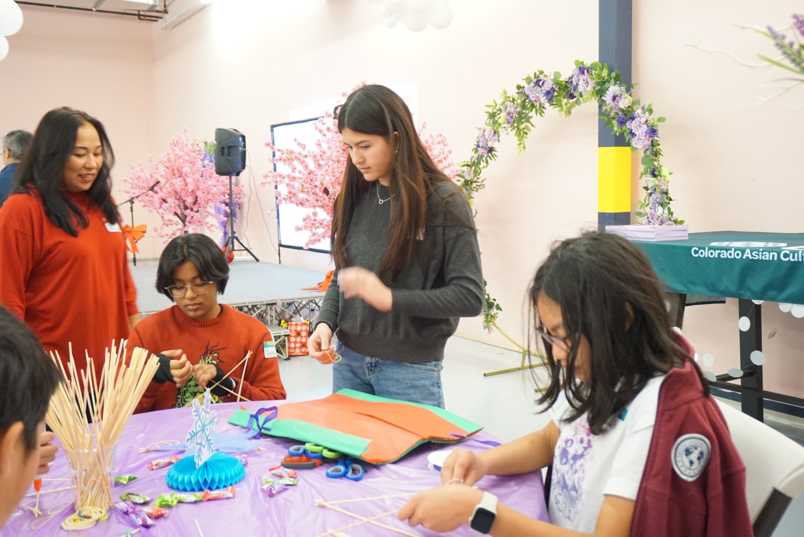  AGI students in conversation creating Filipino Parol at AGI Holiday Social 