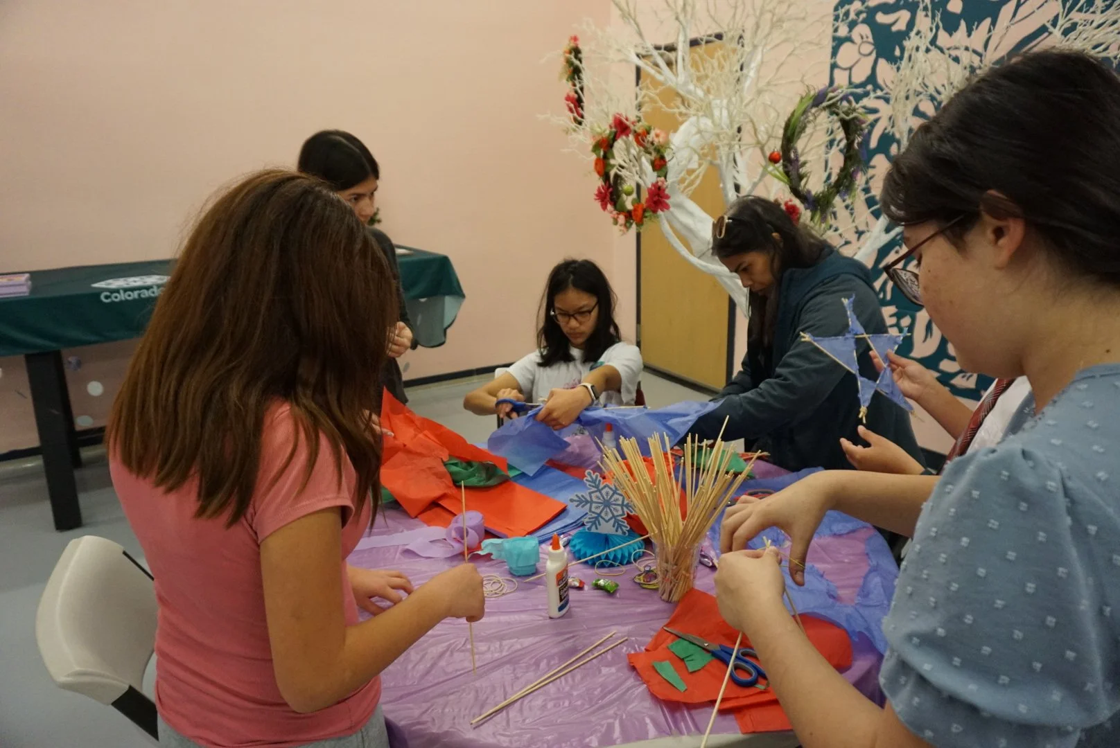 AGI students in conversation creating Filipino Parol at AGI Holiday Social 
