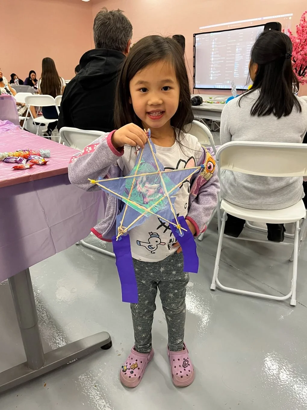  Child smiling and holding Filipino Parol made at AGI Holiday Social  