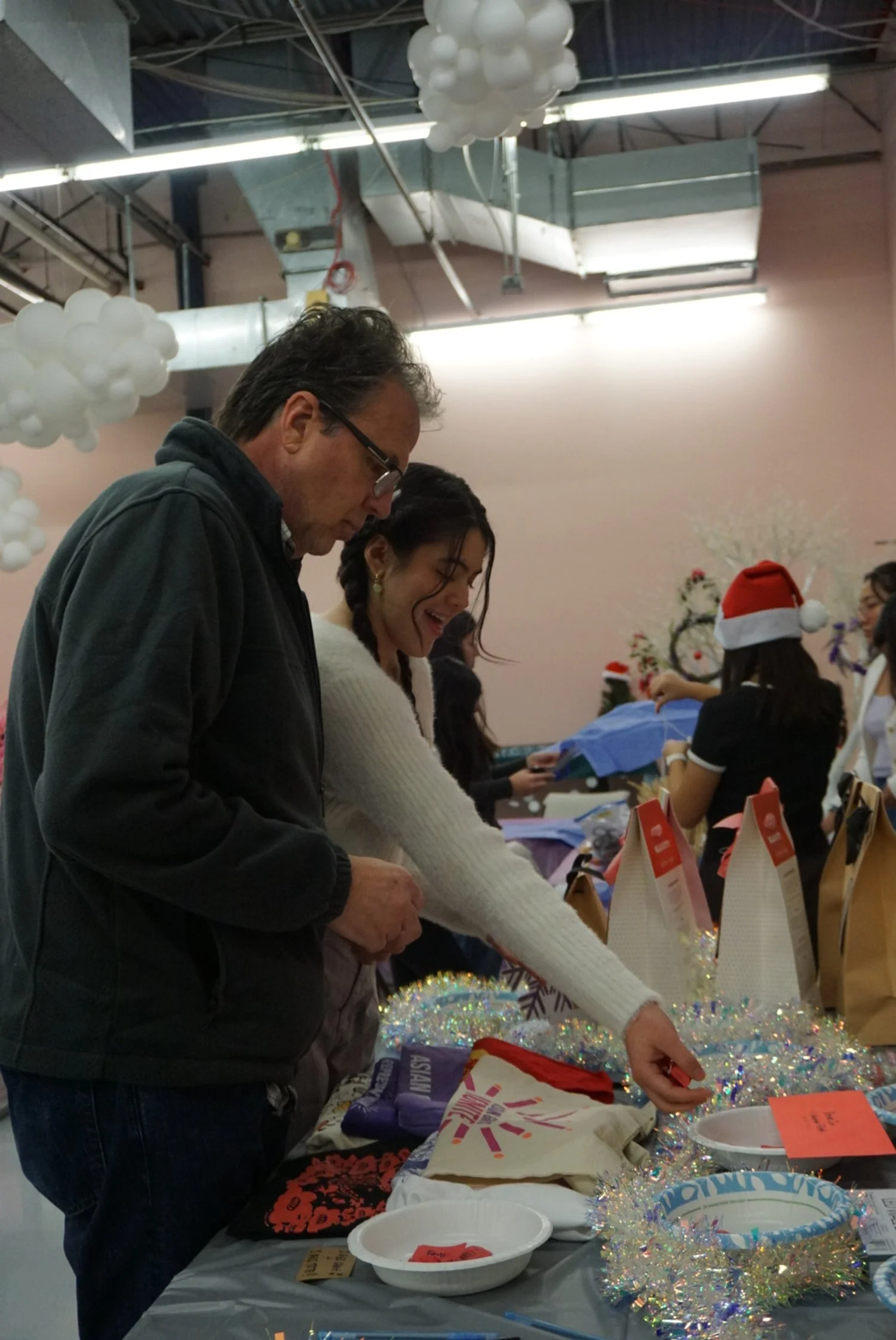  Student and family drop tickets into raffle bowl at AGI Holiday Social  