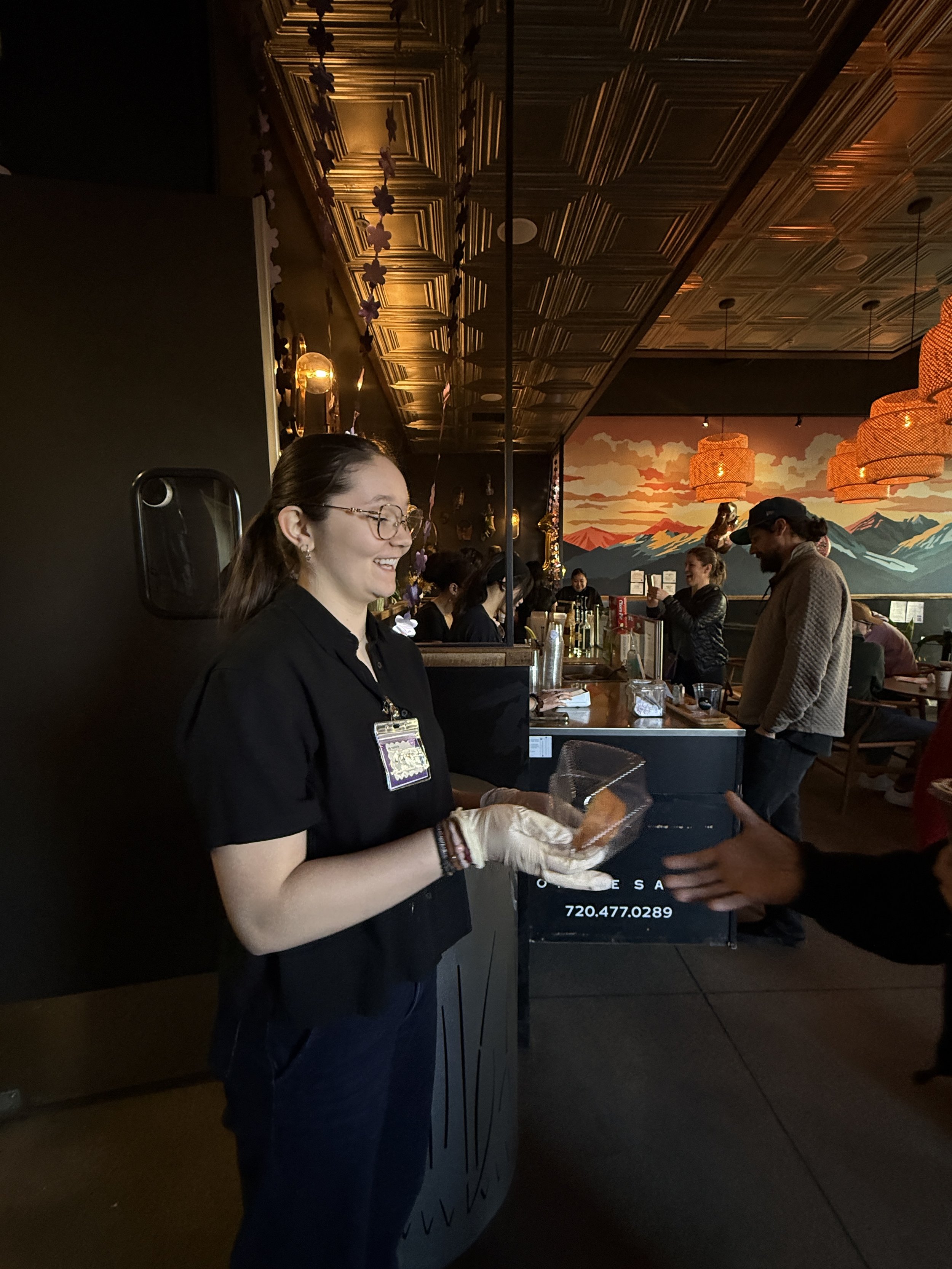  Student hands over prepared treat in a plastic container at Coffee Sarap. 