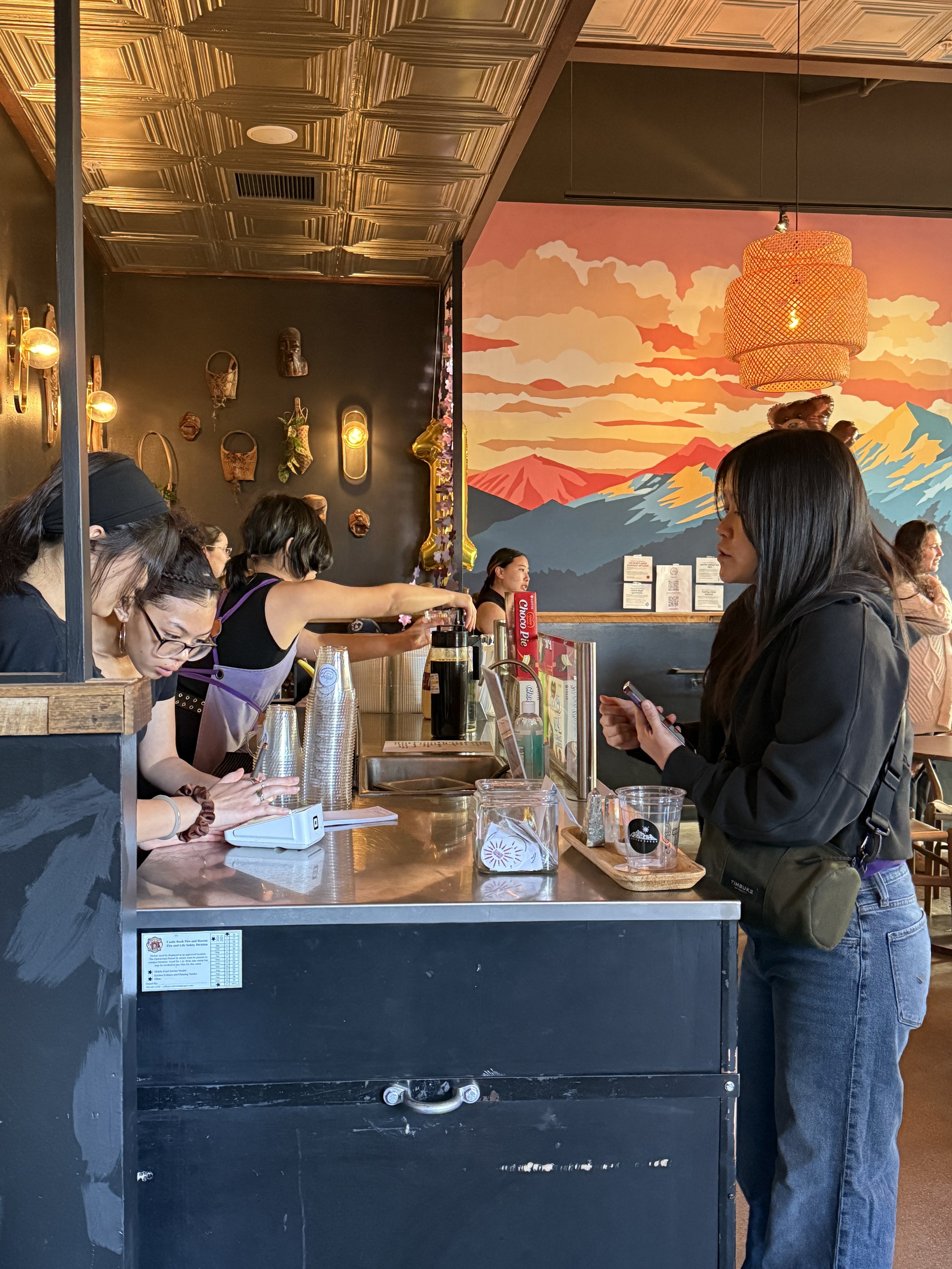  Students take orders at indoor coffee cart at Coffee Sarap. 