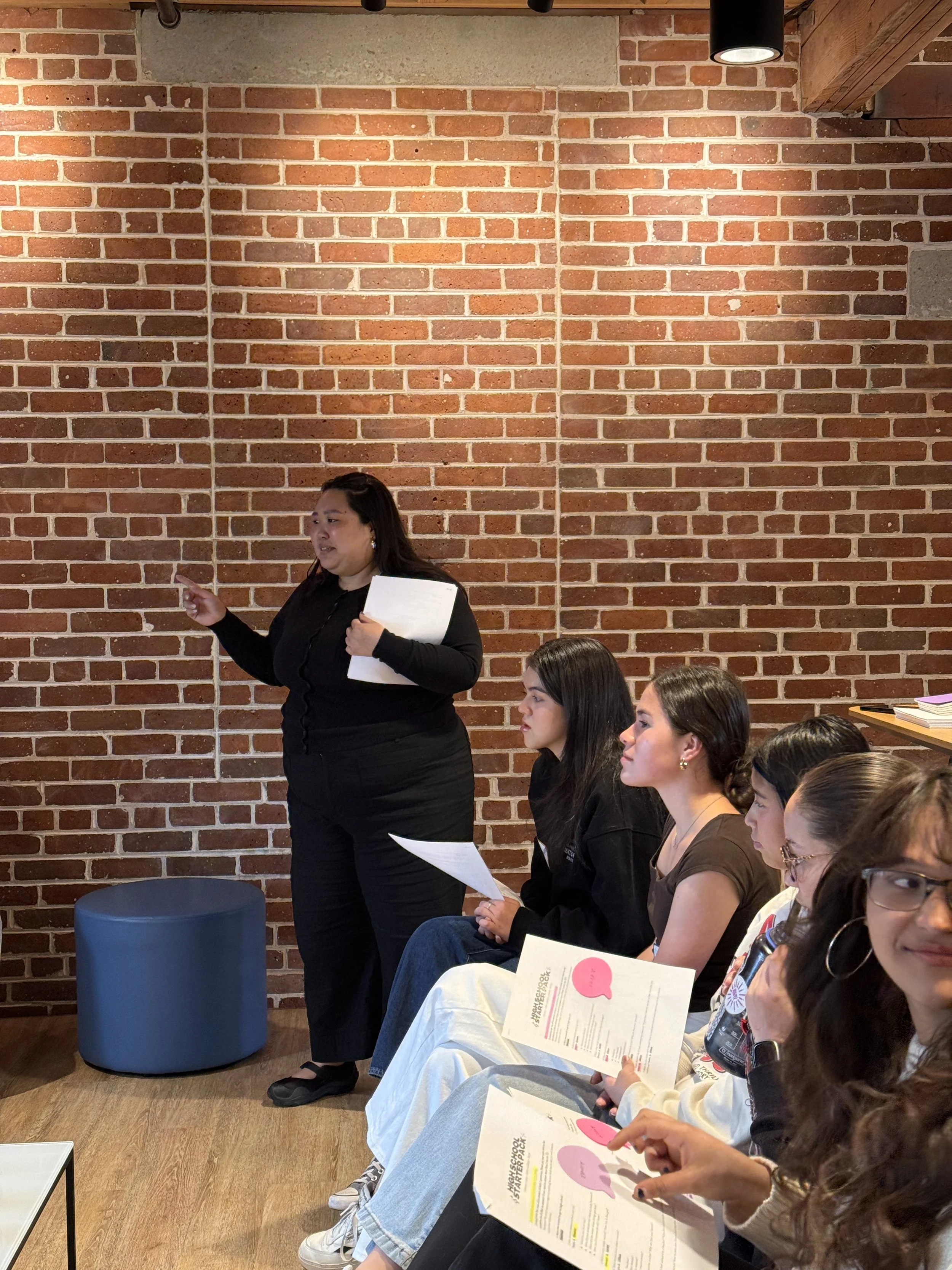  Jihee Yoon speaks to AGI middle school students at High School Starter Guide Event in brick wall room  