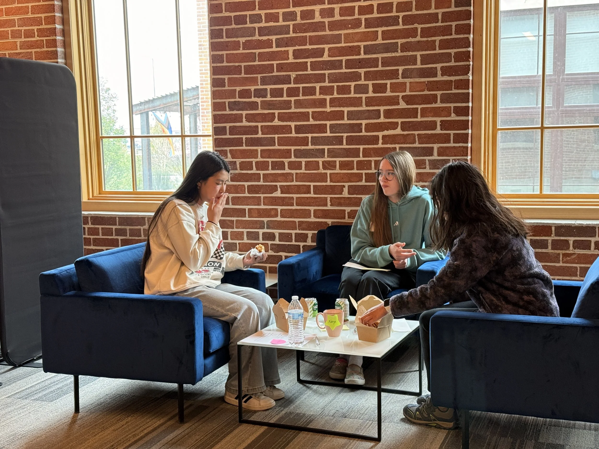  High school mentor speaks with middle school mentees at event with lunch 