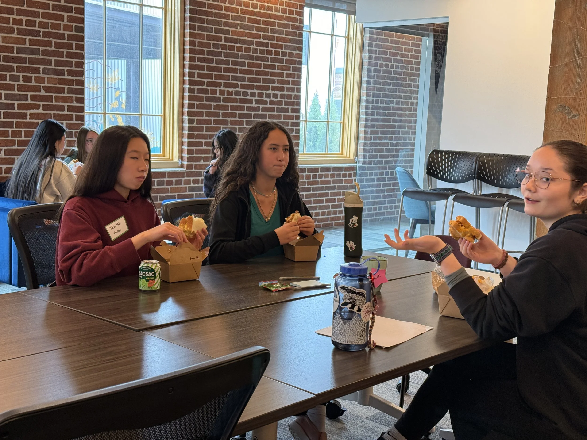 High school mentor speaks with middle school mentees at event with lunch 