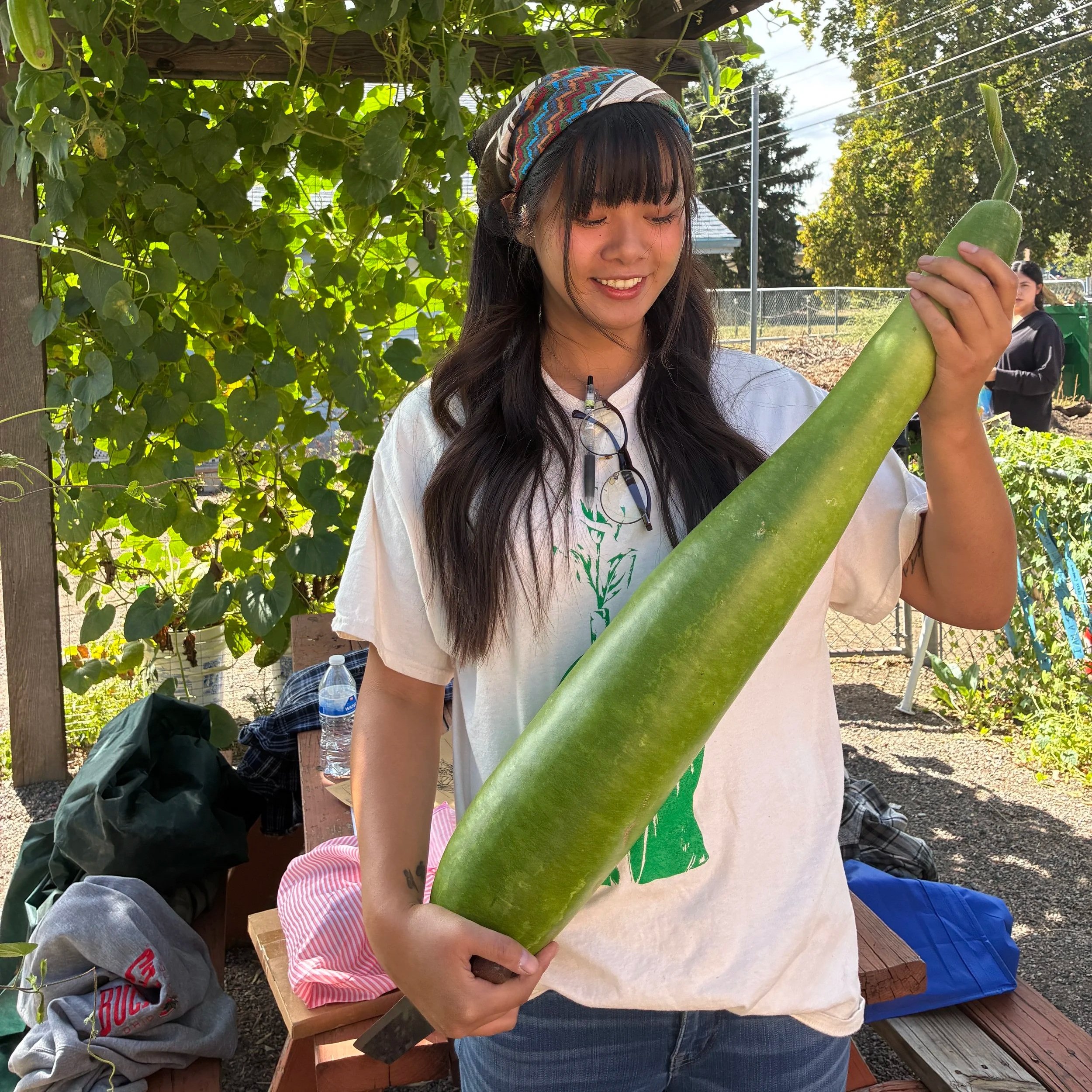 asian american holding a vegetable